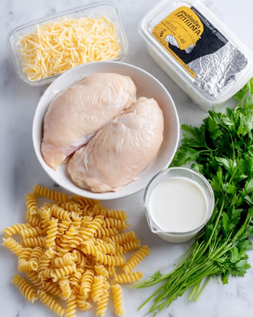 A white bowl holds two raw chicken pieces with a pale pink and smooth texture, sitting side by side. Nearby, there is a small clear container filled with shredded pale yellow cheese. A measuring cup contains white milk next to a small block of silver-wrapped cream cheese. Some uncooked yellow spiral pasta is spread out in front of a black and yellow container labeled with pasta brand text. In the background, fresh green leafy parsley is arranged. All items are placed on a white marbled surface. Photo taken with an iphone --ar 4:5 --v 7