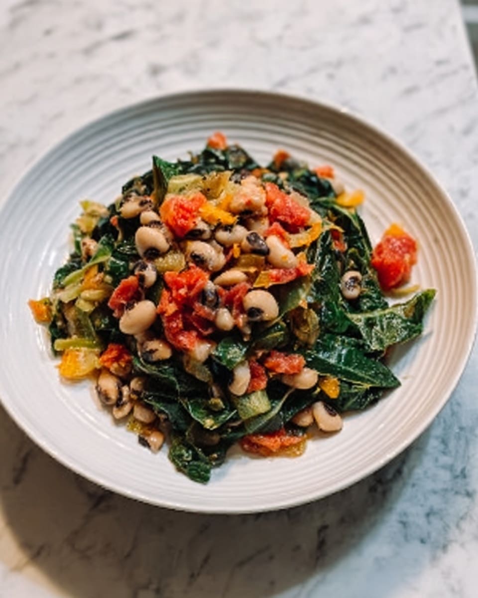 The dish is served on a white plate placed on a white marbled surface. It features several layers: the bottom layer has cooked leafy greens with a slightly wilted texture and dark green color. On top are white and black speckled beans scattered evenly, giving a soft and smooth look. Bright red chopped tomatoes are spread throughout, adding spots of color, and finely chopped orange pieces are mixed in as well. The dish appears mixed but still shows distinct layers of beans, greens, and tomatoes, creating a colorful and healthy look. The photo taken with an iphone --ar 4:5 --v 7