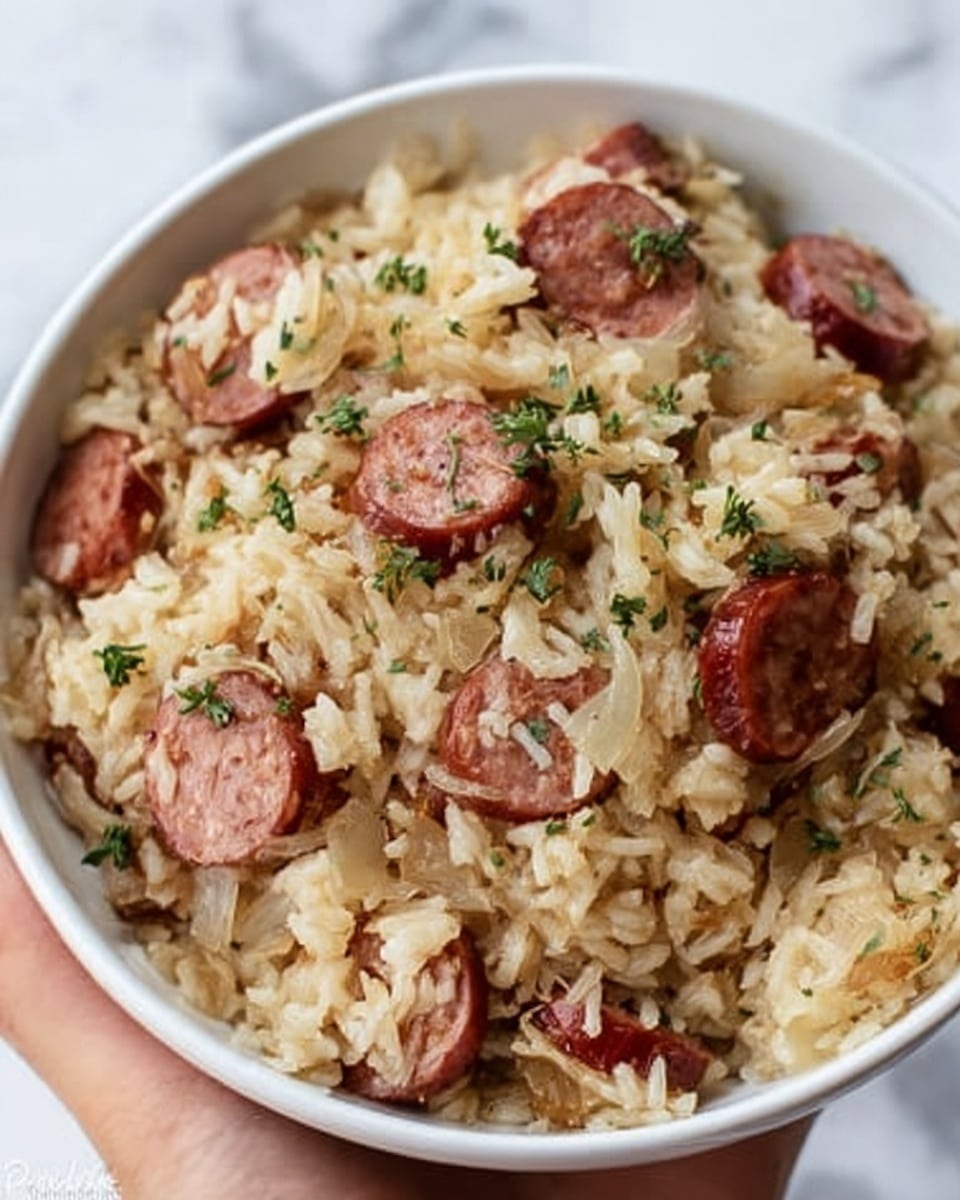 The image shows a black pan filled with a dish made of cooked white rice mixed with small yellow pieces, likely pineapple or cooked vegetables. On top of the rice are several thick, shiny, brown sausages cut into large chunks. A woman’s hand with a wooden spoon is stirring the food, giving a sense of movement to the rice and sausages. The background is a white marbled texture. photo taken with an iphone --ar 4:5 --v 7