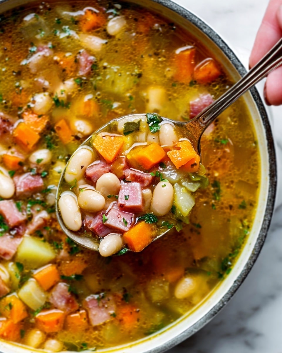The image shows a close-up of a white pot filled with chunky soup containing several layers of ingredients: large white beans, orange carrot cubes, small pieces of pink ham, and green herbs, all floating in a golden broth that looks slightly oily and shiny. A silver spoon filled with the same ingredients is lifted above the soup, with a woman’s hand gently holding the spoon handle. The background surface is white marble, adding a clean and bright contrast to the warm soup colors. The photo has a sharp and vibrant look, captured with an iPhone --ar 4:5 --v 7