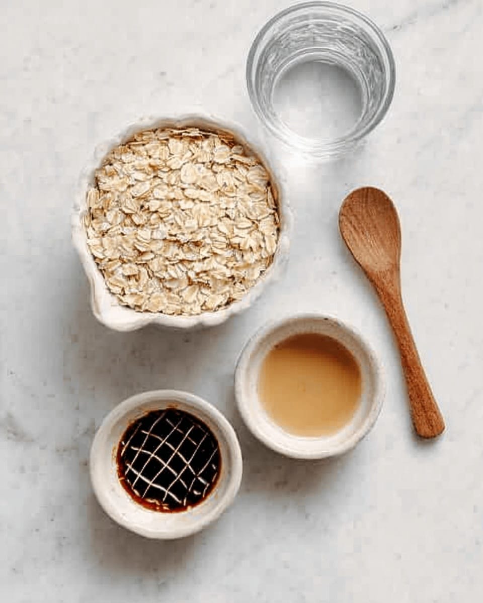 This image shows a white measuring cup filled with light beige rolled oats sitting on a white marbled surface. Below it are two small white bowls: the left bowl holds a dark brown sauce with a grid pattern on top, and the right bowl contains a light brown liquid. To the right of the bowls is a wooden spoon with a rounded handle placed on the surface. A clear glass of water is positioned behind the bowls, adding a transparent element. photo taken with an iphone --ar 4:5 --v 7