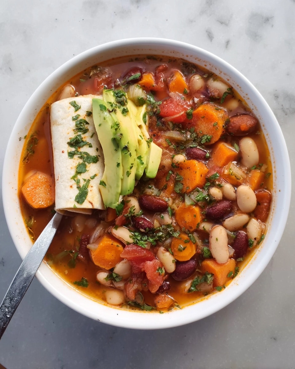 A white bowl filled with a thick soup containing various beans, orange carrot slices, small tomato pieces, and sprinkled green herbs. On top of the soup are two folded white tortilla pieces layered with thin avocado slices and sprinkled herbs. A silver spoon is placed inside the bowl, resting in the soup. The bowl is set on a white marbled surface. Photo taken with an iphone --ar 4:5 --v 7