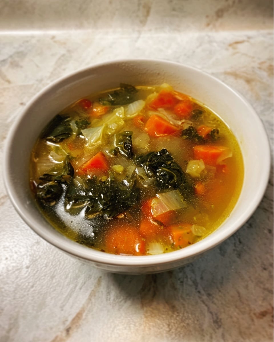 A white bowl filled with a clear broth soup containing small, uneven pieces of orange carrots, dark green leafy vegetables, and light yellow bits of onion or cabbage floating on top. The soup looks light and fresh with a mix of small vegetable chunks scattered throughout. The bowl sits on a countertop with a white marbled texture background. Photo taken with an iphone --ar 4:5 --v 7