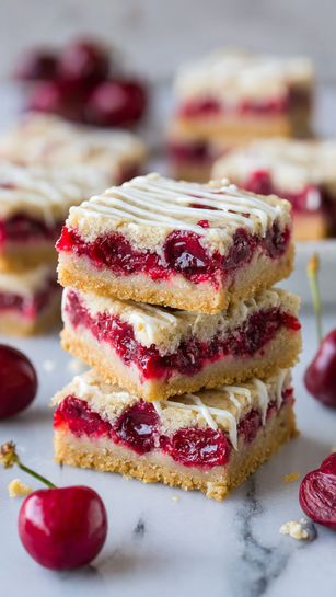 The image shows three stacked dessert bars on a wooden surface with a white marbled background. Each bar has three layers: the bottom layer is a firm, golden-brown crust; the middle layer is bright red with visible whole cranberries pressed together; the top layer is light golden with crumbly oat pieces adding texture. The bars appear thick and slightly uneven at the top, showing a homemade feel. The focus is sharp on the stack, making the colors and textures clear. Photo taken with an iphone --ar 4:5 --v 7