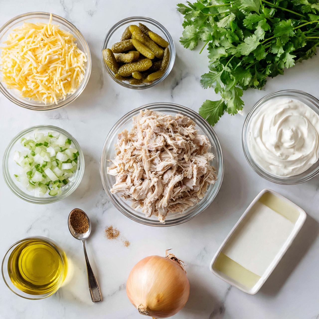The image shows a white marbled surface with several clear glass bowls and white containers arranged neatly. In the center is a clear bowl filled with shredded cooked chicken. Below it, there is a small stack of soft flour tortillas. To the top left, a glass bowl holds shredded yellow cheese, and next to it is a small glass of light yellow liquid, possibly juice. To the left center, there is a white container with sliced green pickles, and to the bottom left, a small clear bowl contains a light yellow liquid, likely oil. In the bottom center, a white spoon holds a small amount of light brown seasoning, while a second spoon next to it holds a finer light brown powder. To the right of the tortillas, a small clear bowl contains a white powdery ingredient, possibly salt. To the right edge of the image, a bunch of fresh green cilantro sits next to a whole brown onion. photo taken with an iphone --ar 4:5 --v 7