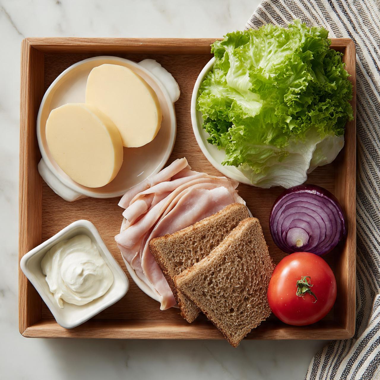 A wooden tray holds sandwich ingredients arranged neatly on a white marbled surface. At the top left, two round slices of pale yellow cheese rest on a small white dish. Next to it on the right, a bunch of fresh green lettuce lies with ruffled leaves facing up. Below the cheese, thin slices of light pink turkey are placed on another small white dish. To the right of the turkey, two slices of brown whole wheat bread are stacked. At the bottom left, a dollop of white mayonnaise is in a small white square bowl. On the bottom right side of the tray, a whole red tomato and a whole purple onion sit side by side. A striped cloth is partially visible at the top right corner. Photo taken with an iphone --ar 4:5 --v 7