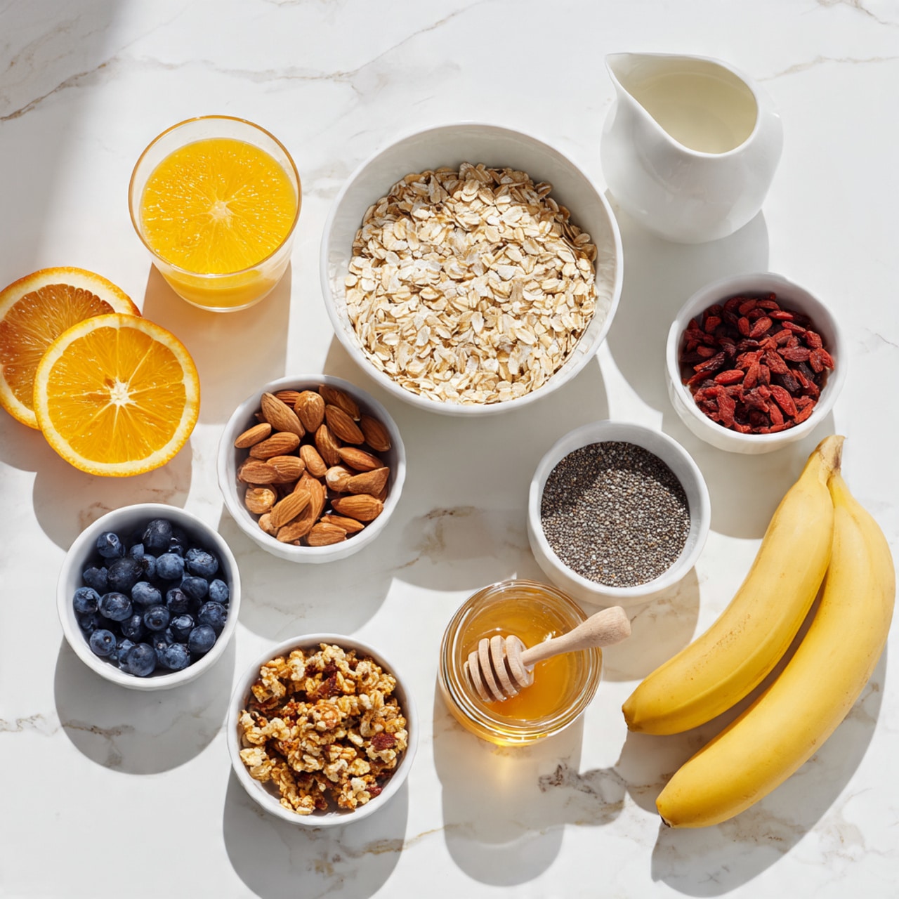 The image shows five large russet potatoes with rough brown skins stacked on a white marbled surface at the left. To the right, there are several small clear glass bowls with different ingredients: one with a white creamy substance, one with chopped green onions, one with butter squares, one with a mix of salt and powdery seasoning, and one with olive oil. There is a larger white bowl filled with bright yellow shredded cheddar cheese and another white bowl containing crispy cooked bacon pieces. At the back, a clear glass measuring cup holds white milk. All items are arranged neatly with bright natural light, and the texture and colors of each ingredient are clear and detailed. Photo taken with an iphone --ar 4:5 --v 7