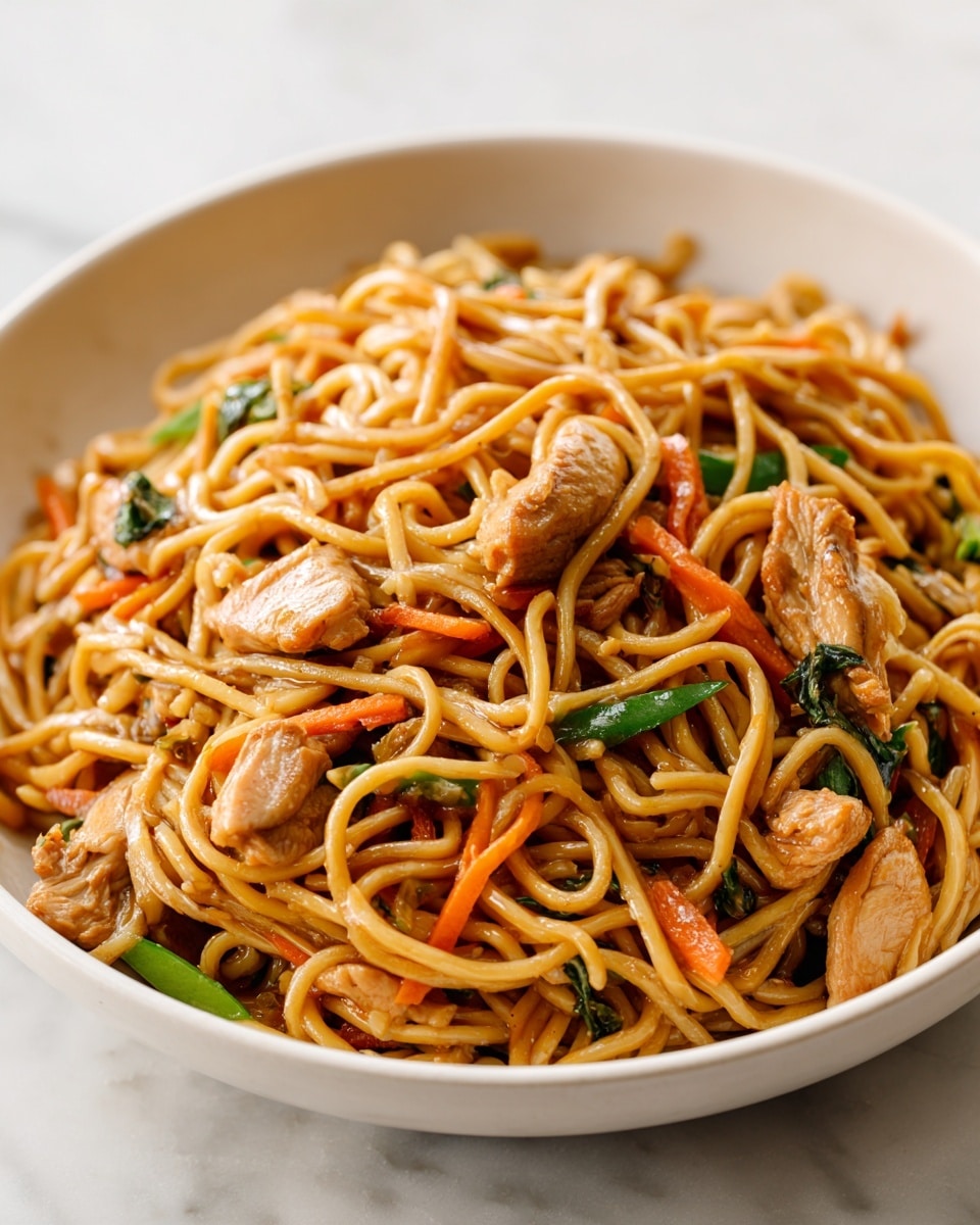A white bowl filled with stir-fried noodles that are light brown and glossy, mixed with pieces of cooked chicken that are light tan and tender-looking. Bright orange thin carrot sticks and a few green vegetable pieces are scattered evenly throughout the noodles, adding color contrast. The noodles and ingredients are intertwined, giving a textured and slightly tangled look. The bowl is placed on a white marbled surface with soft natural lighting highlighting the shine on the noodles and meat photo taken with an iphone --ar 4:5 --v 7