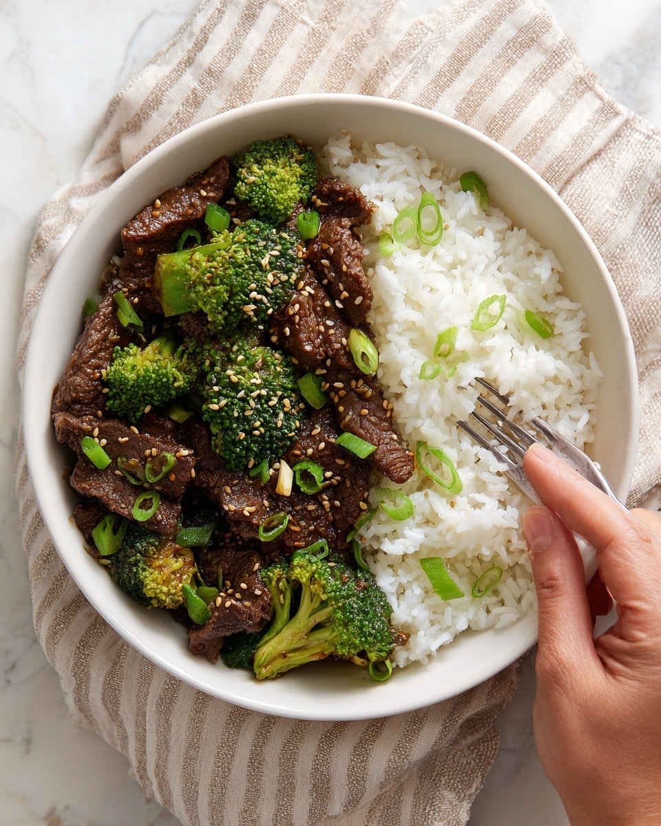 A speckled grey bowl with a rustic edge holds a two-layer dish on a white marbled surface. The bottom half has a mound of plain white rice, soft and slightly sticky. The top half is filled with dark brown pieces of cooked beef mixed with bright green broccoli florets. The beef looks tender and shiny with sauce, sprinkled with light tan sesame seeds and topped with fresh green scallion slices. A fork rests in the bowl, held by a woman's hand, digging into the rice. The bowl sits on a beige cloth with dark stripes. Photo taken with an iphone --ar 4:5 --v 7