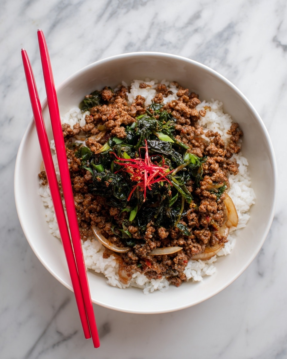 A white bowl filled with a base layer of soft white rice topped with a mix of cooked ground meat and thinly sliced onions in a brown sauce. On top of this, there is a small pile of dark green leafy vegetables at the center. Two bright red chopsticks rest across the rim of the bowl. The bowl is placed on a white marbled surface. photo taken with an iphone --ar 4:5 --v 7
