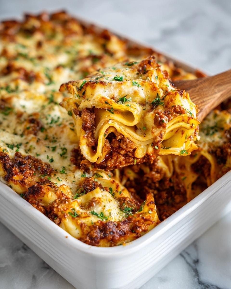 A white rectangular dish filled with a layered pasta bake, the top layer covered with melted, lightly browned cheese and sprinkled with small green herb pieces. Underneath, visible noodles are folded and mixed with a rich sauce made of ground meat and tomato, showing a deep red and brown color. A wooden spoon lifts some pasta from the bottom right corner, revealing thick pasta and sauce layers inside. The dish sits on a white marbled surface. Photo taken with an iphone --ar 4:5 --v 7