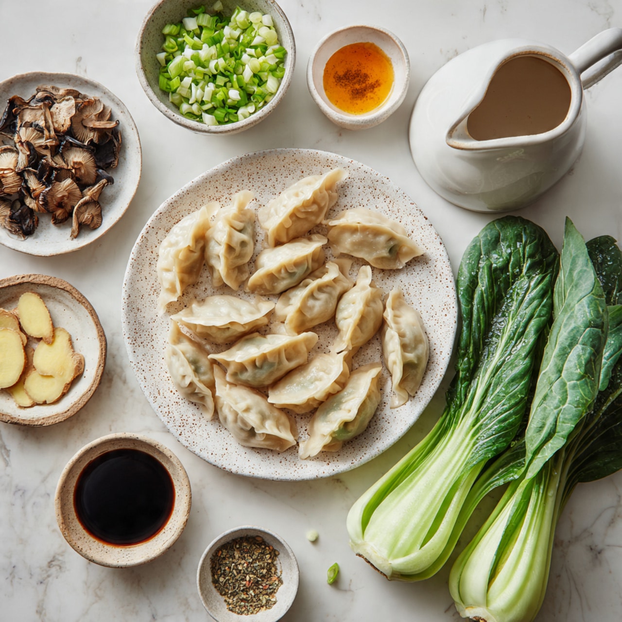 The image shows raw dumplings placed on a white plate with brown speckles, arranged in a loose pile with soft, doughy textures that are light beige with subtle darker spots from the filling beneath the thin skin. To the right, there are three fresh green bok choy leaves with visible water drops on their crisp veins and stems. Above the plate is a small white bowl filled with chopped green onions, vibrant and fresh with a mix of light and dark green rings. To the bottom left, a white bowl holds dried shiitake mushrooms, dark brown and wrinkled with some lighter brown edges. Surrounding these main items are several small bowls and dishes with various ingredients: thin slices of light beige ginger and garlic cloves on a white plate, a small bowl with dark soy sauce, another with a lighter golden sauce, a tiny bowl with black pepper, and a white sauce pitcher with an orange-colored sauce. The entire setup is on a white marbled surface. photo taken with an iphone --ar 4:5 --v 7