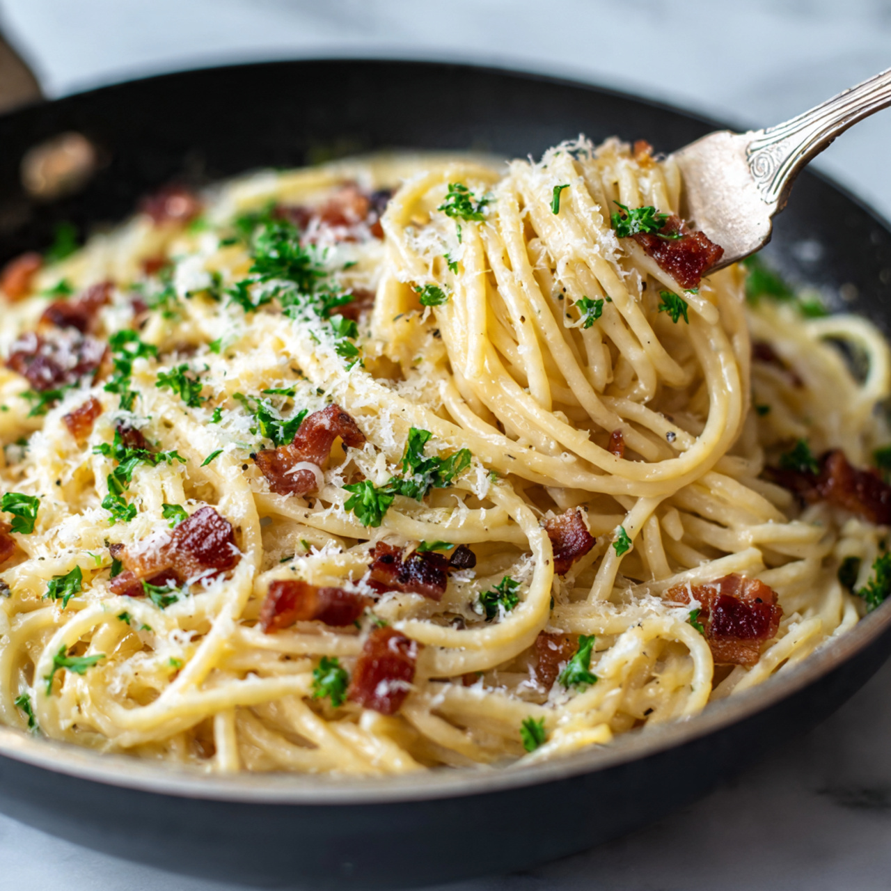 A close-up view of creamy spaghetti with a light beige sauce, mixed with small dark brown crispy bacon strips and sprinkled with finely grated white cheese and green parsley bits on top. The spaghetti is wrapped around a fork, showing smooth, shiny pasta strands coated in sauce. The food is in a black pan placed on a white marbled surface. Photo taken with an iphone --ar 4:5 --v 7