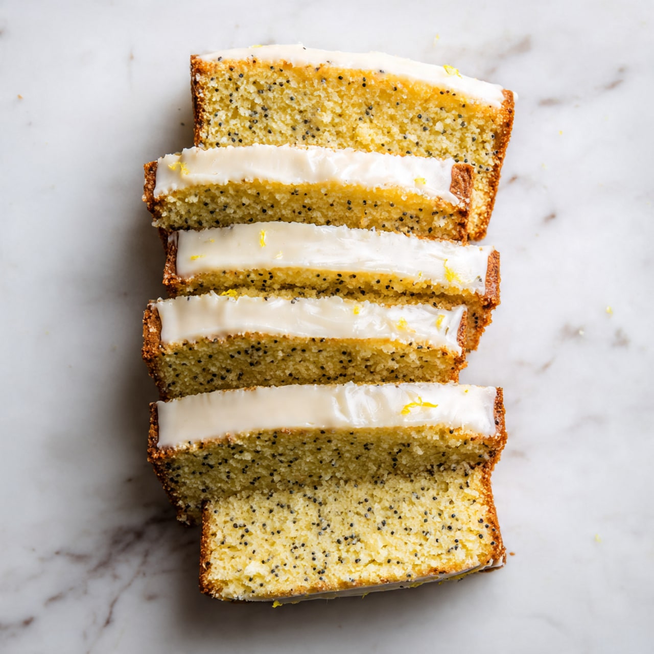 The image shows six slices of a light yellow cake with small dark seeds inside, stacked slightly overlapping on a white marbled surface. Each slice is topped with a thin layer of smooth, white icing that glistens slightly. The texture of the cake looks soft and moist with a crumbly crust on the edges. The slices are arranged vertically from top to bottom, with the top slice leaning slightly backward. The white marbled surface adds a clean and bright background that contrasts with the cake's light and textured look. Photo taken with an iphone --ar 4:5 --v 7