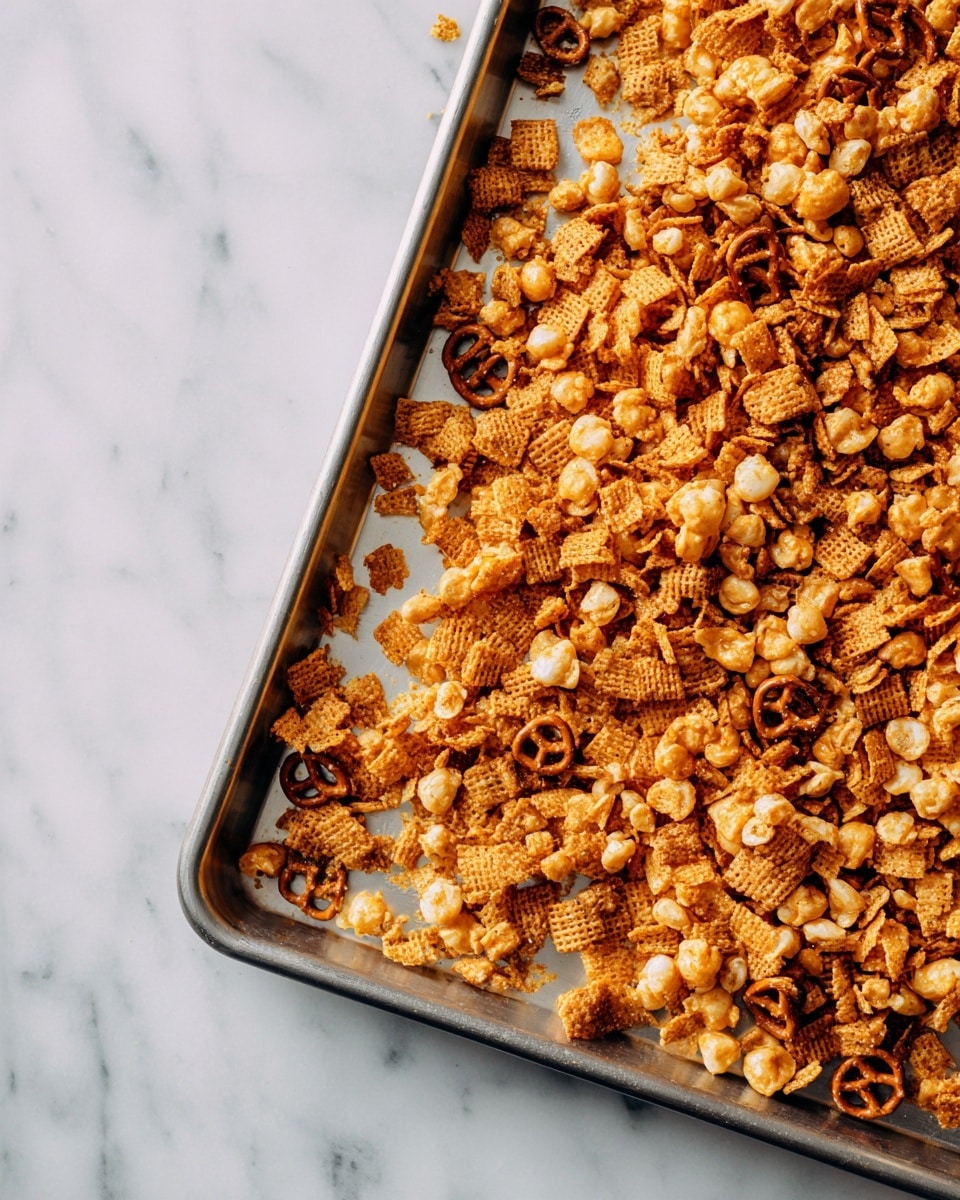 A metal baking tray filled with many small crunchy cereal pieces spread all over. The cereal pieces are golden brown and look crisp with some darker brown twisted pretzels mixed in. The tray is placed on a white marble surface. photo taken with an iphone --ar 4:5 --v 7