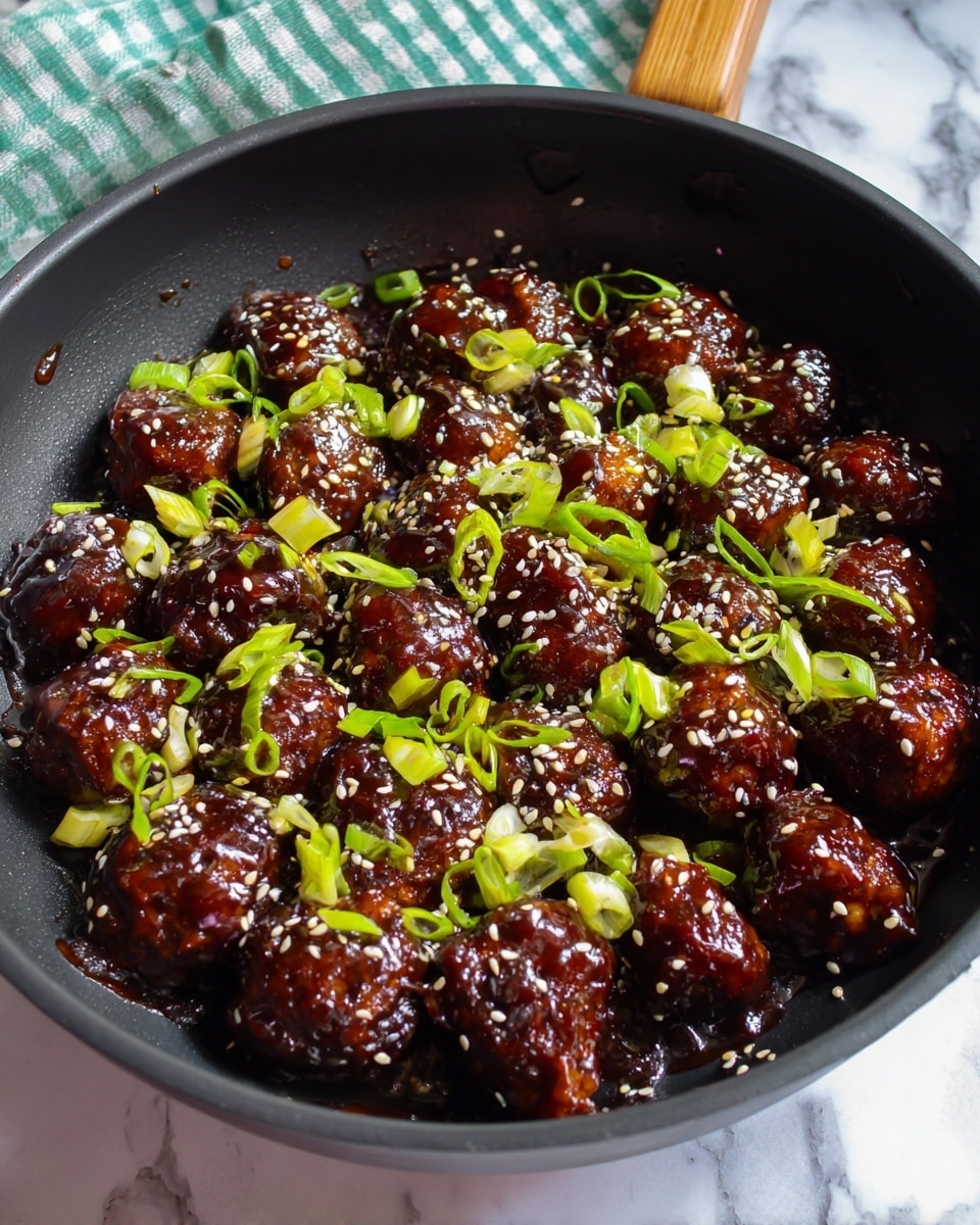 A black pan filled with round, dark brown glazed pieces of food, each piece shiny with a thick sauce. The dish is topped with small, bright green chopped spring onions and sprinkled with white and black sesame seeds. The pan is on a white marbled surface with a hint of a green and white checkered cloth in the background. photo taken with an iphone --ar 4:5 --v 7