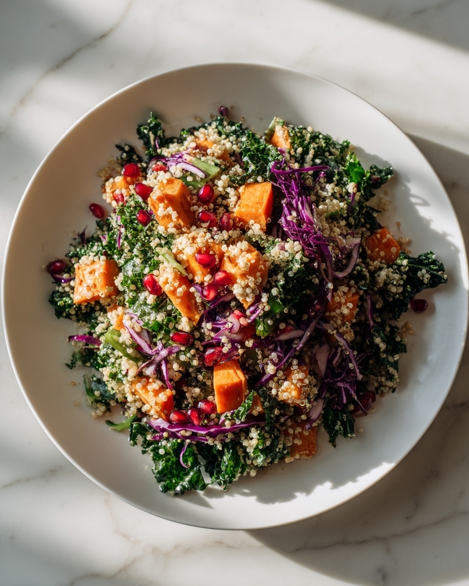 A large white plate filled with a colorful salad sits on a white marbled surface. The dish has several layers: the bottom layer is fresh green kale leaves, roughly torn; scattered on top are small, puffy quinoa grains creating a light beige layer. Bright orange chunks of cooked sweet potato are evenly spread over the quinoa. Thin strands of purple cabbage add a vibrant touch, mixed with light green kale stems. The salad looks fresh and textured with small bits of pomegranate seeds scattered throughout, adding tiny pops of red. The light and shadows suggest soft natural lighting. photo taken with an iphone --ar 4:5 --v 7