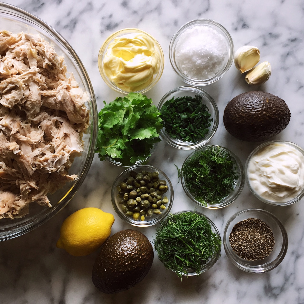 square image The image shows various ingredients arranged on a white marbled surface. On the left, there is a large clear bowl filled with shredded light brown chicken meat. Surrounding it are smaller clear bowls containing creamy yellow mayonnaise, coarse salt, fresh bright green cilantro leaves, chopped dark green chives, small green capers, fresh green dill, and thick white sour cream. There are also two whole dark brown avocados, a yellow lemon, two peeled garlic cloves, and a small bowl with ground black pepper. All items are neatly spaced with clear visibility of each element. photo taken with an iphone --ar 4:5 --v 7