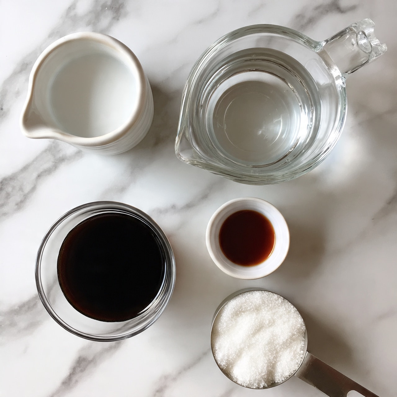square image Five clear containers with different liquids and powders sit on a white marbled surface. The top left container is a small white ceramic pitcher filled with a white liquid. To the right of it is a clear glass measuring cup with a handle and a spout, filled halfway with clear water. Below the pitcher is a clear glass cup filled with dark black coffee. To the right of the coffee is a tiny white ceramic bowl containing a small amount of dark brown liquid. At the bottom right is a metal measuring cup filled with white granulated sugar. photo taken with an iphone --ar 4:5 --v 7
