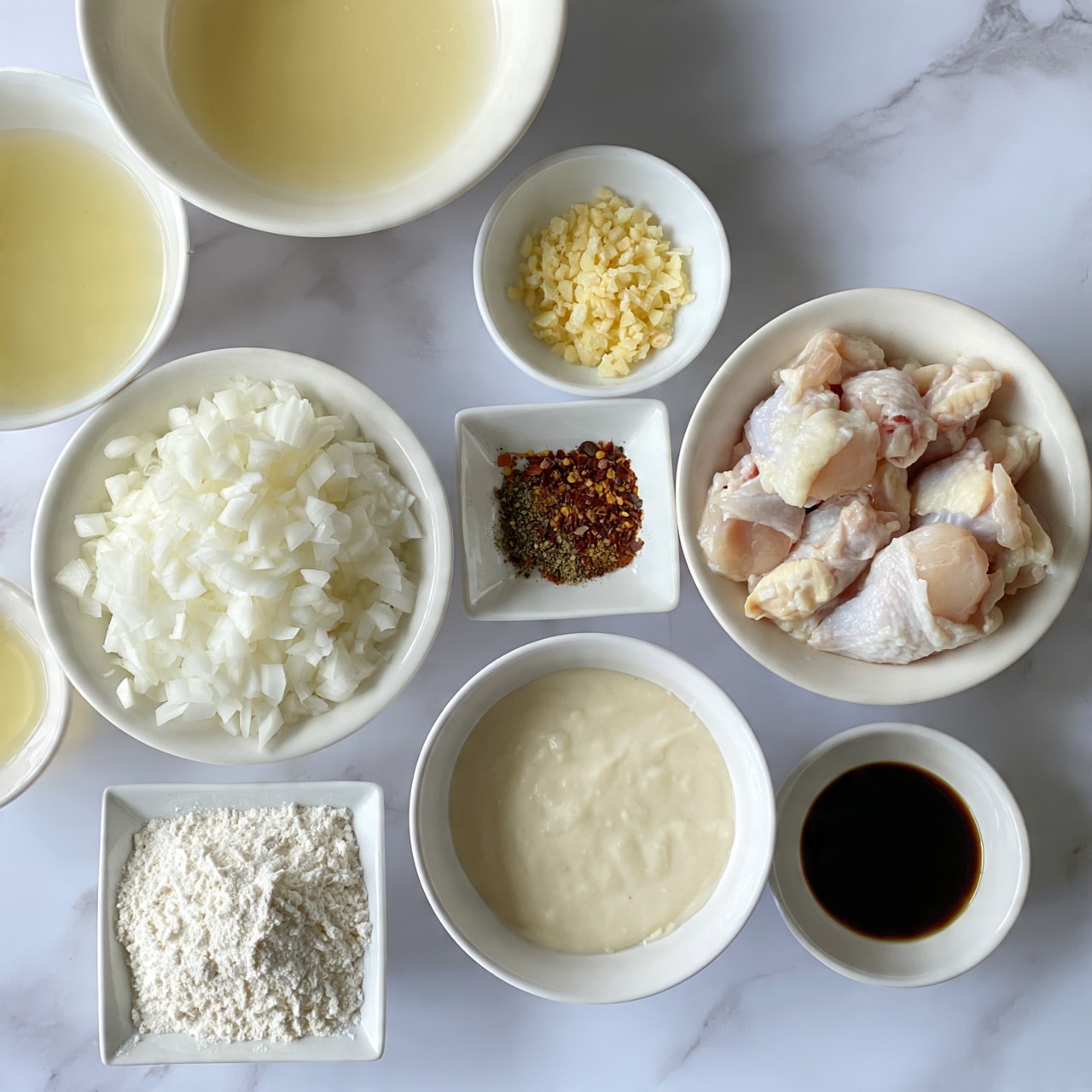 square image The image shows an overhead view of multiple small white bowls arranged on a white marbled surface, each holding a different ingredient. One bowl contains raw chicken pieces with pale pink skin placed on the right side. Below it, a small white bowl holds a dark liquid. To the left of the chicken, a large white bowl is filled with finely chopped white onions. Above that is another large white bowl with a pale yellow liquid. Near the top center, a small white bowl holds minced light yellow garlic. Below the garlic, a small square white bowl contains a mix of red, brown, and green spices. To the left, a small white bowl has a clear yellow liquid. At the bottom left, a square white bowl holds white flour. Finally, a medium white bowl filled with a creamy pale batter is placed in the middle right area. The setup is neat and well-lit, with all bowls evenly spaced. Photo taken with an iphone --ar 4:5 --v 7s