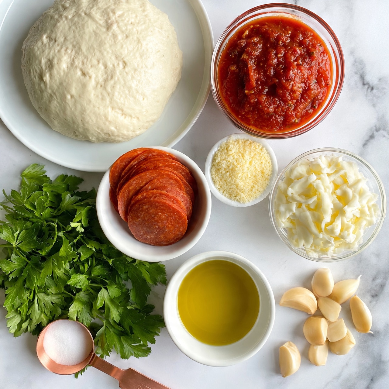 square image The image shows six bowls and a bunch of green parsley arranged on a white marbled surface. The top left bowl contains a smooth, pale dough ball with a slightly textured surface, placed on a white plate. To its right, a clear bowl holds thick, red tomato sauce with some texture. Below the dough, a white bowl has round slices of reddish-brown pepperoni stacked neatly inside. To the right of the pepperoni, a small white bowl is filled with pale yellow grated Parmesan cheese, showing a fine, crumbly texture. Next to the Parmesan, a clear bowl contains shredded white mozzarella cheese with a soft, stringy look. Below the cheeses, a white bowl contains golden yellow olive oil with a smooth surface. Scattered to the right of the oil are several light beige garlic cloves with smooth skins. A copper measuring spoon with white salt is positioned on the left side near the parsley, which is vibrant green with flat leaves and visible veins. The photo taken with an iphone --ar 4:5 --v 7