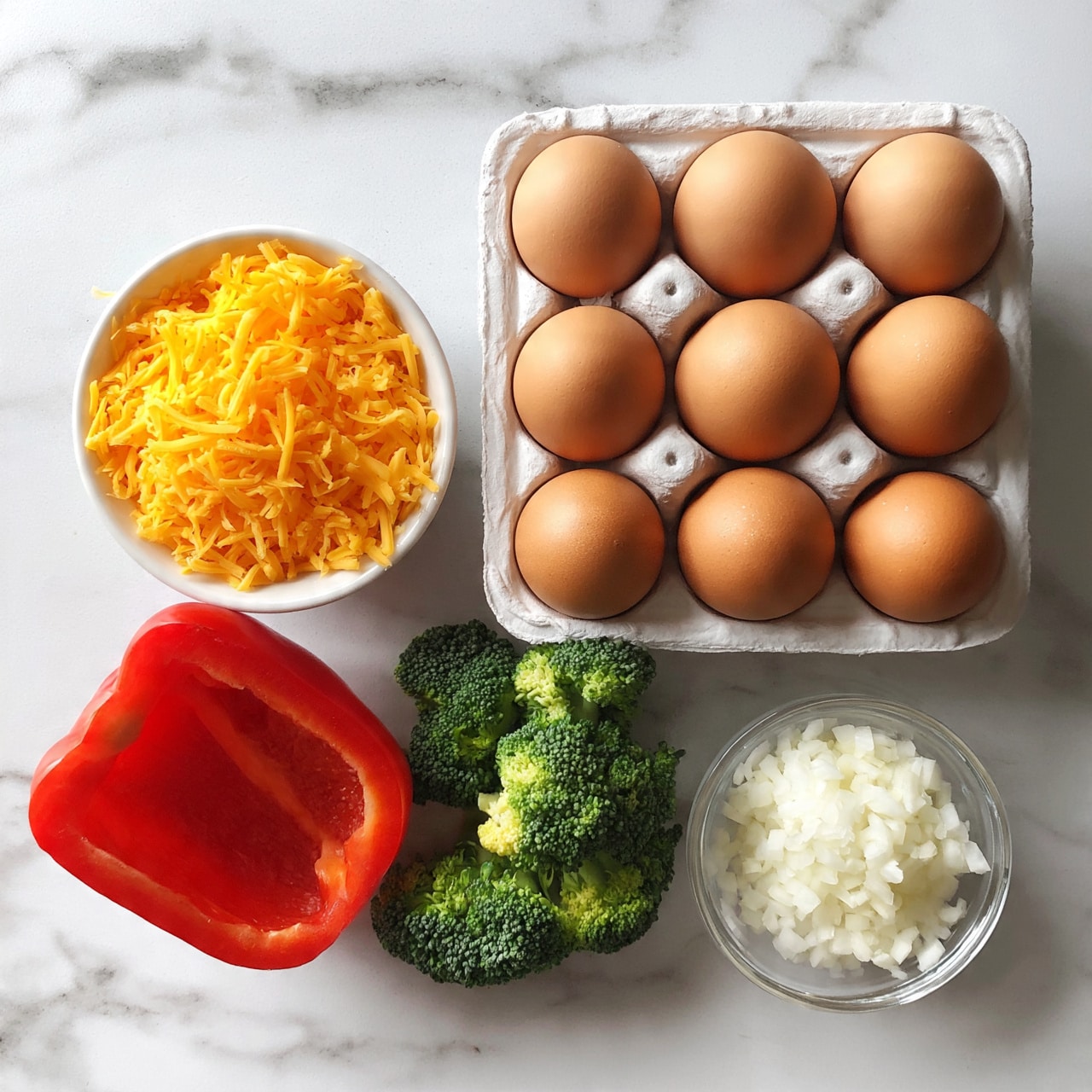 square image A white egg carton with ten brown eggs in two neat rows sits on a white marbled surface, next to a small white bowl filled with shredded orange cheddar cheese, a halved red bell pepper, a small pile of bright green broccoli florets, and a small clear bowl containing finely chopped white onions; all items are arranged closely together, showing fresh, natural textures and rich colors. photo taken with an iphone --ar 4:5 --v 7