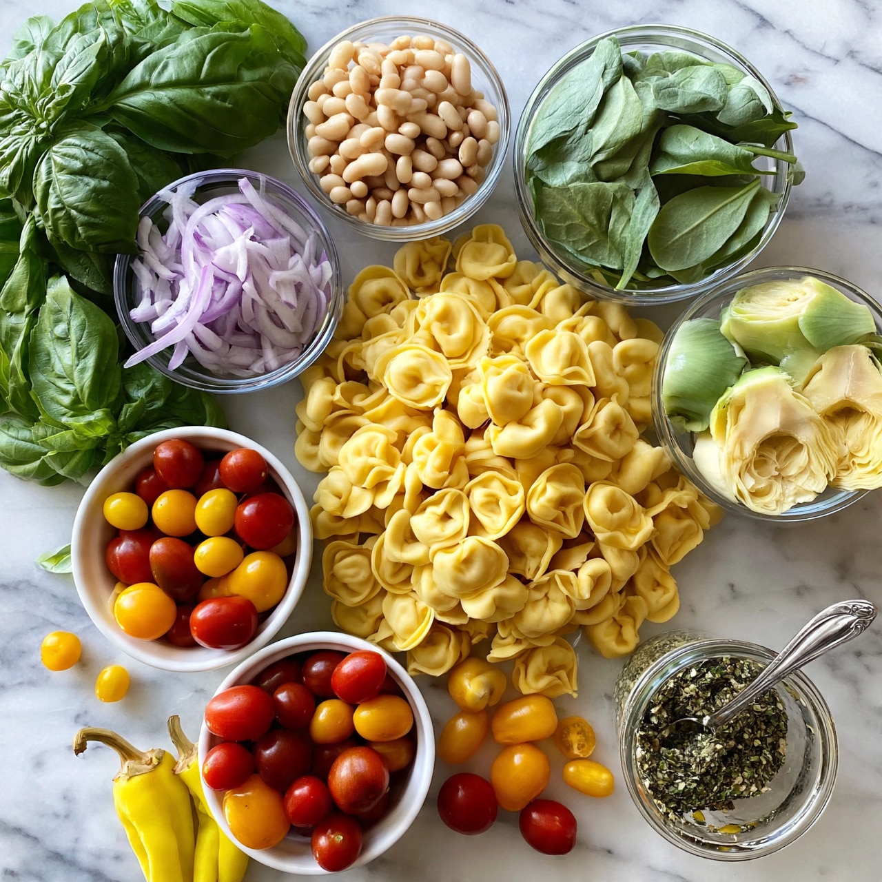 square image The image shows a spread of fresh ingredients on a white marbled surface. There is a large amount of uncooked tortellini pasta in the center, pale yellow in color with a smooth texture. Around the pasta, in small white bowls or clear glass bowls, there are light beige beans, pale purple thinly sliced onions, light green spinach leaves, and artichoke hearts with a soft green and creamy yellow color. A bunch of fresh bright green basil leaves is on the left side, while a small white bowl is filled with round red and orange cherry tomatoes, some loose tomatoes scattered nearby. A glass container holds a herb mix with a silver spoon inside, and a few yellow pepperoncini with stems rest near the bottom left. The overall scene is bright and fresh, with a neat and colorful arrangement on the white marbled surface photo taken with an iphone --ar 4:5 --v 7
