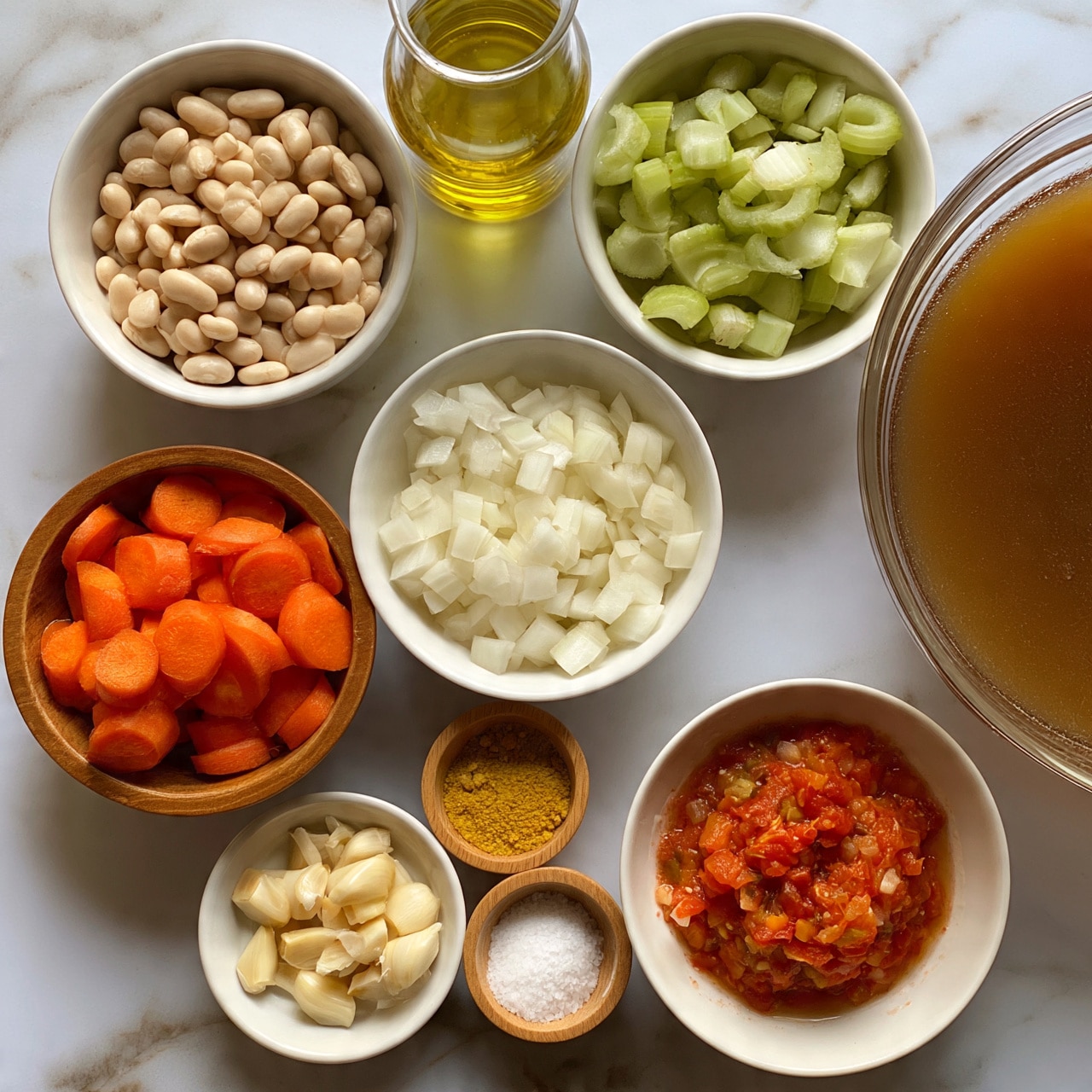 square image The image shows several white bowls and wooden bowls on a white marbled surface, each containing different cooking ingredients arranged neatly. One white bowl is filled with small white beans, another white bowl holds diced white onions, and a third white bowl contains sliced celery. A wooden bowl contains sliced orange carrots, and another wooden bowl has peeled and chopped garlic cloves. There is a glass container filled with golden-yellow liquid, possibly oil. A small white bowl holds a yellow spice, and another small wooden container has white granulated salt. A white bowl has a red mixture that looks like crushed tomatoes, and a large clear bowl is filled with brownish broth or stock. These elements are placed in a visually balanced spread. Photo taken with an iphone --ar 4:5 --v 7