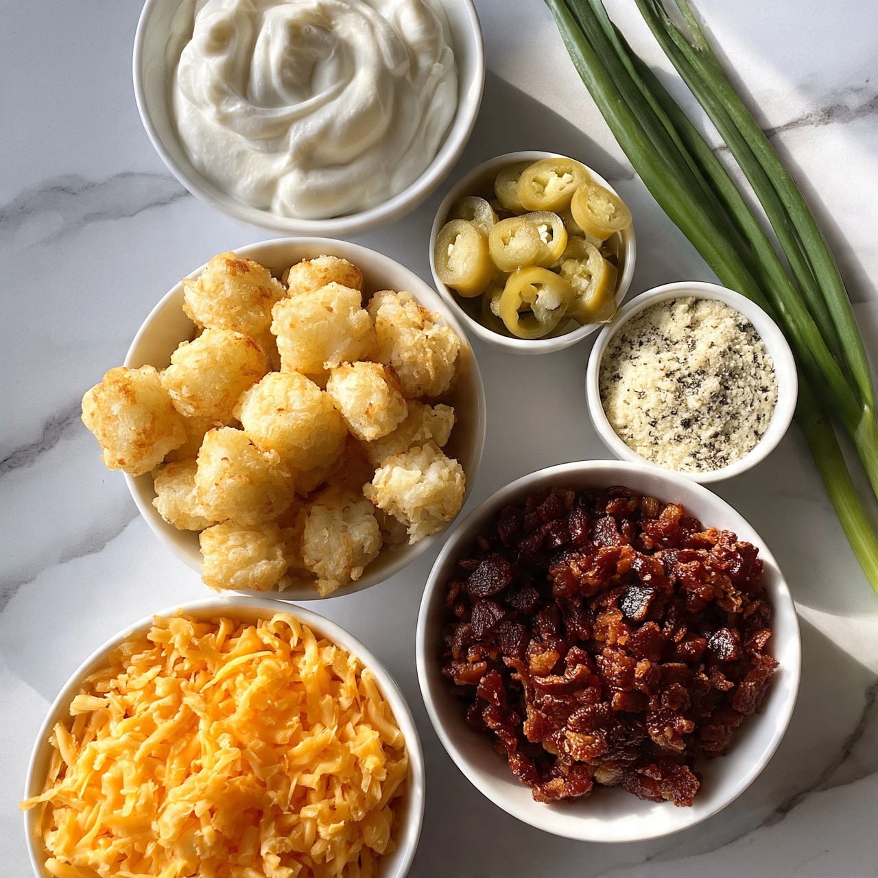 square image The image shows six white bowls placed on a white marbled surface with fresh green onions to the side. The largest bowl at the bottom left is filled with shredded orange cheddar cheese with a soft texture. Above it, a large bowl holds light golden, crispy tater tots with a rough, crunchy texture. To the right of the cheese is a bowl filled with small dark reddish-brown bacon pieces, crisp and slightly shiny. Above the bacon bits, a small bowl contains pale green jalapeño slices with a glossy look, and next to it, a small bowl holds a light powdery seasoning mix with visible black specks. At the top left, a medium-sized bowl is filled with smooth, thick white sour cream, with soft swirls on the surface. Beside these bowls, two long green onions lie on the marble surface. photo taken with an iphone --ar 4:5 --v 7square image