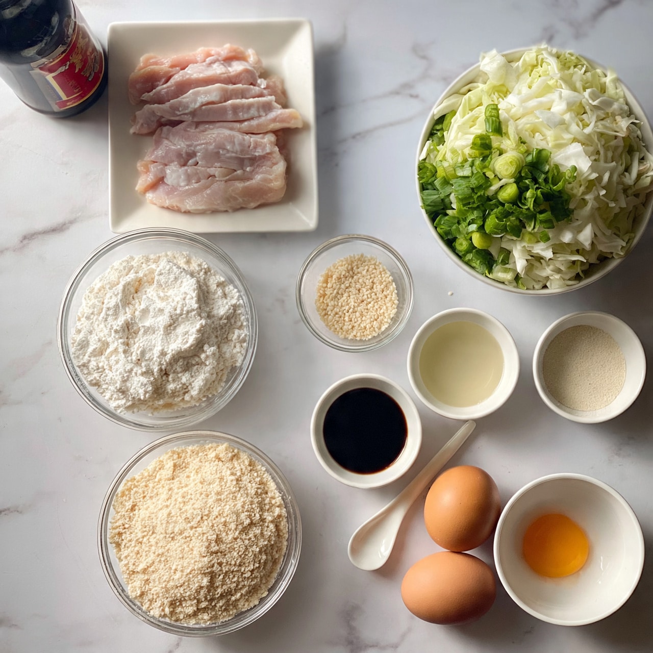 square image A white marbled surface holds a neat arrangement of cooking ingredients: sliced pale pink raw chicken placed on a small white square plate at the top left, next to a dark bottle with red label print; below them are two clear round bowls, one filled with white flour and the other with light beige breadcrumbs. To the right, a small glass bowl with pale sesame seeds is next to a larger white bowl filled with chopped green onions and white cabbage. Two brown eggs sit near the bottom right corner, beside a white bowl containing an egg with a bright orange yolk. Around these are three small white bowls holding dark soy sauce, light-colored oil, and a fine light powder, with a small white spoon resting nearby; everything is evenly spaced for a clear view of each ingredient photo taken with an iphone --ar 4:5 --v 7