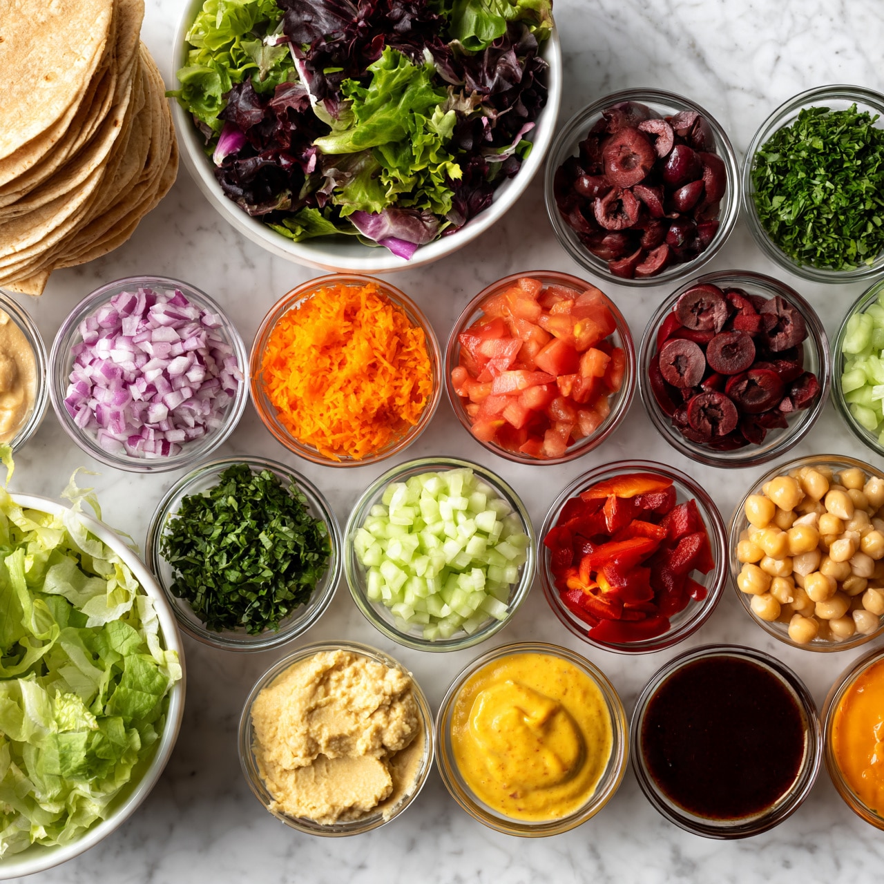 square image The image shows many small clear glass bowls and two white bowls on a white marbled surface, each filled with different fresh ingredients for making wraps. On the top left, there are stacked light brown tortillas, next to a white bowl with mixed green and purple leafy salad. Below, another white bowl holds light green leafy lettuce. The small bowls are arranged in neat rows containing chopped red onions, bright orange shredded carrots, fresh diced tomatoes, sliced dark red olives, light green diced cucumbers, dark red sliced peppers, chopped green herbs, light yellow hummus, light golden chickpeas, and sauces in shades of yellow, dark brown, and orange. The textures vary from smooth pastes to crunchy vegetables, and all items are vibrant in color and fresh-looking. Photo taken with an iphone --ar 4:5 --v 7