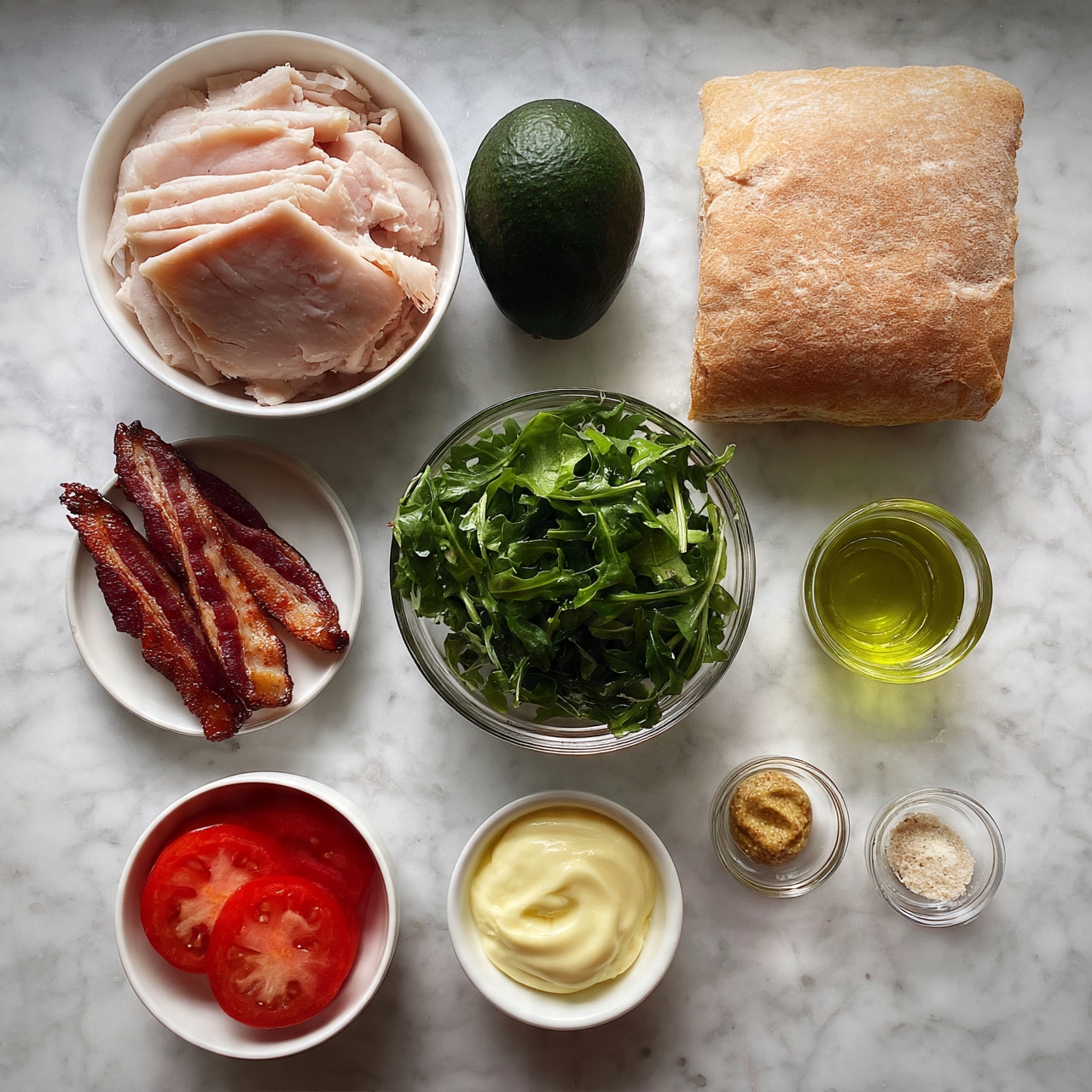 square image The image shows ingredients neatly arranged on a white marbled surface. On the top left, there is a white bowl filled with light pink sliced turkey placed next to a dark green whole avocado. To the right, there is a square, light brown sandwich roll with a slightly crusty texture. Below, on the left side, a small white plate holds three crisp, dark red and brown strips of cooked bacon. In the center, a clear glass bowl is filled with fresh dark green arugula leaves. To the right of the arugula, a small clear glass cup contains light green olive oil. Below the bacon, there is a small white bowl with three bright red tomato slices. At the bottom center, a white bowl contains pale yellow mayonnaise. A small clear glass dish with light brown mustard and another small clear glass dish with white or light beige seasoning complete the layout. Photo taken with an iphone --ar 4:5 --v 7