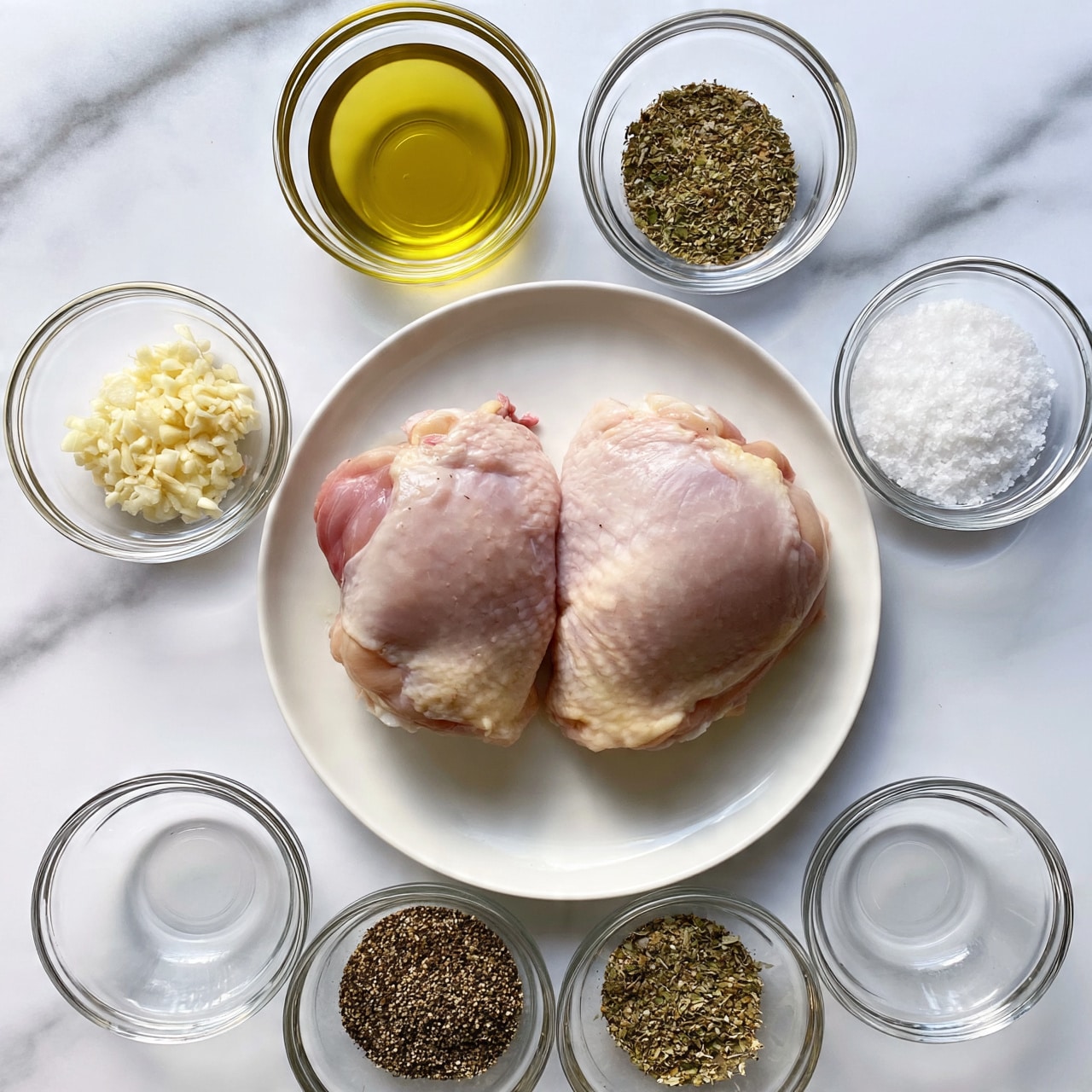 square image The image shows two pieces of raw chicken thighs placed side by side on a white plate, each piece with a pale pink color and a soft skin layer. Surrounding the plate on a white marbled surface are six clear glass bowls arranged in two rows: the top row has a bowl filled with golden olive oil on the left and a bowl with dried herbs on the right; the middle row has minced garlic in the left bowl and coarse white salt in the right bowl; the bottom row has two bowls containing black pepper on the left and a mix of dried herbs on the right. The whole set up is neat and bright, highlighting the natural colors and textures of each ingredient. photo taken with an iphone --ar 4:5 --v 7