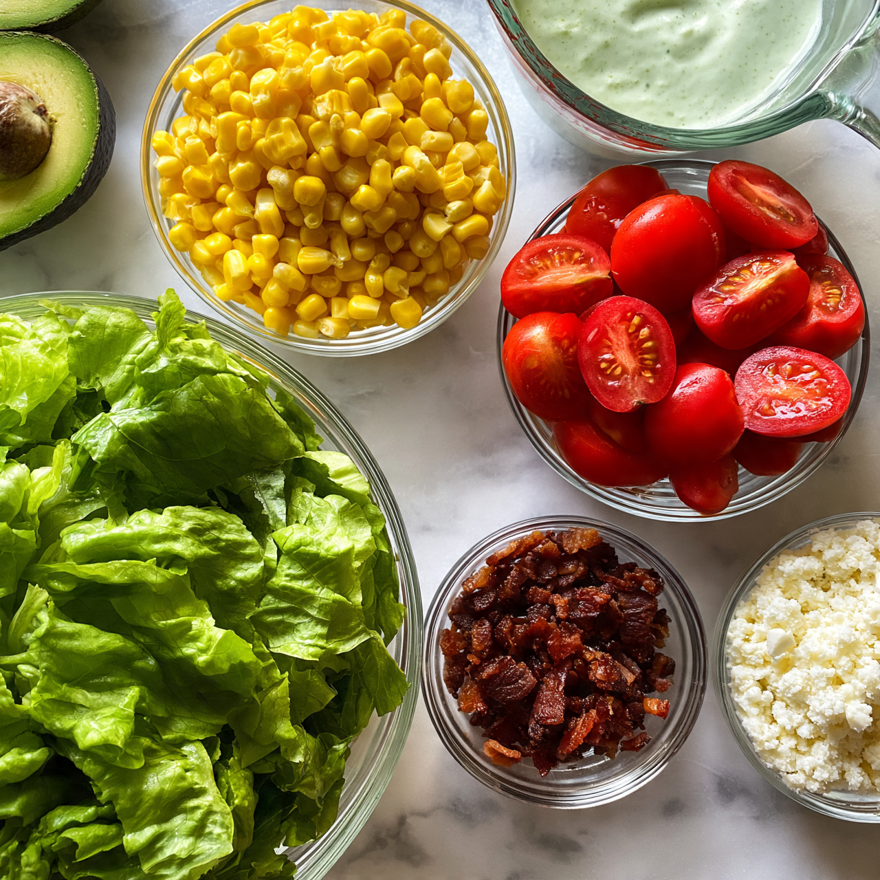 square image The image shows ingredients for a fresh salad arranged on a white marbled surface. There is a large clear bowl filled with bright green leafy lettuce in the bottom left. Above it is a clear bowl with bright yellow corn kernels. To the right of the corn is a bowl with halved red cherry tomatoes, showing their juicy texture. Near the top right is a glass measuring cup with light green creamy dressing. Below the tomatoes is a small clear bowl with dark brown crispy bacon bits, and beside it is another small clear bowl filled with crumbly white cheese. On the left edge of the image, there are two green avocado halves with the seed still inside one. Photo taken with an iphone --ar 4:5 --v 7