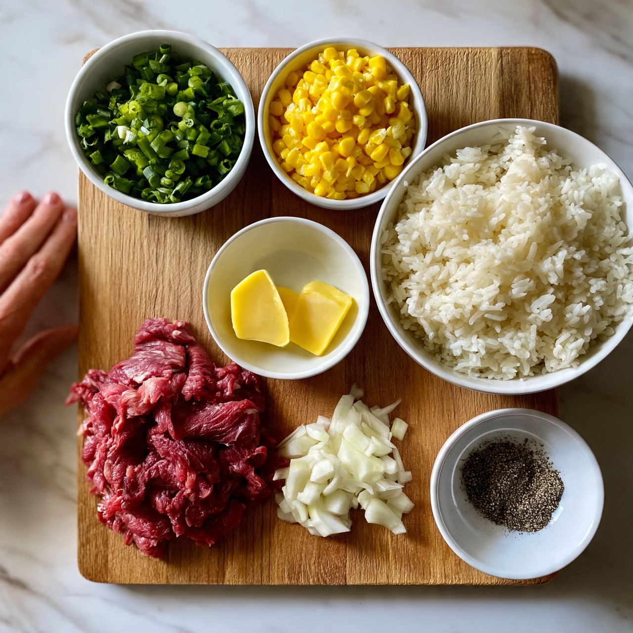 square image The image shows a wooden board on a white marbled surface holding six small bowls and piles of ingredients arranged neatly. Starting from the top left, there is a white bowl filled with chopped green onions, next to it a white bowl with bright yellow corn kernels, and a larger white bowl filled with fluffy white rice on the top right. Below these, in the center, is a small white bowl with two yellow butter slices. On the bottom left, there is a pile of thin, raw red meat slices, next to it on the right are sliced white onions arranged in a small mound. On the bottom right, a small white bowl contains black pepper. A woman's hand is just visible on the left side of the board. photo taken with an iphone --ar 4:5 --v 7
