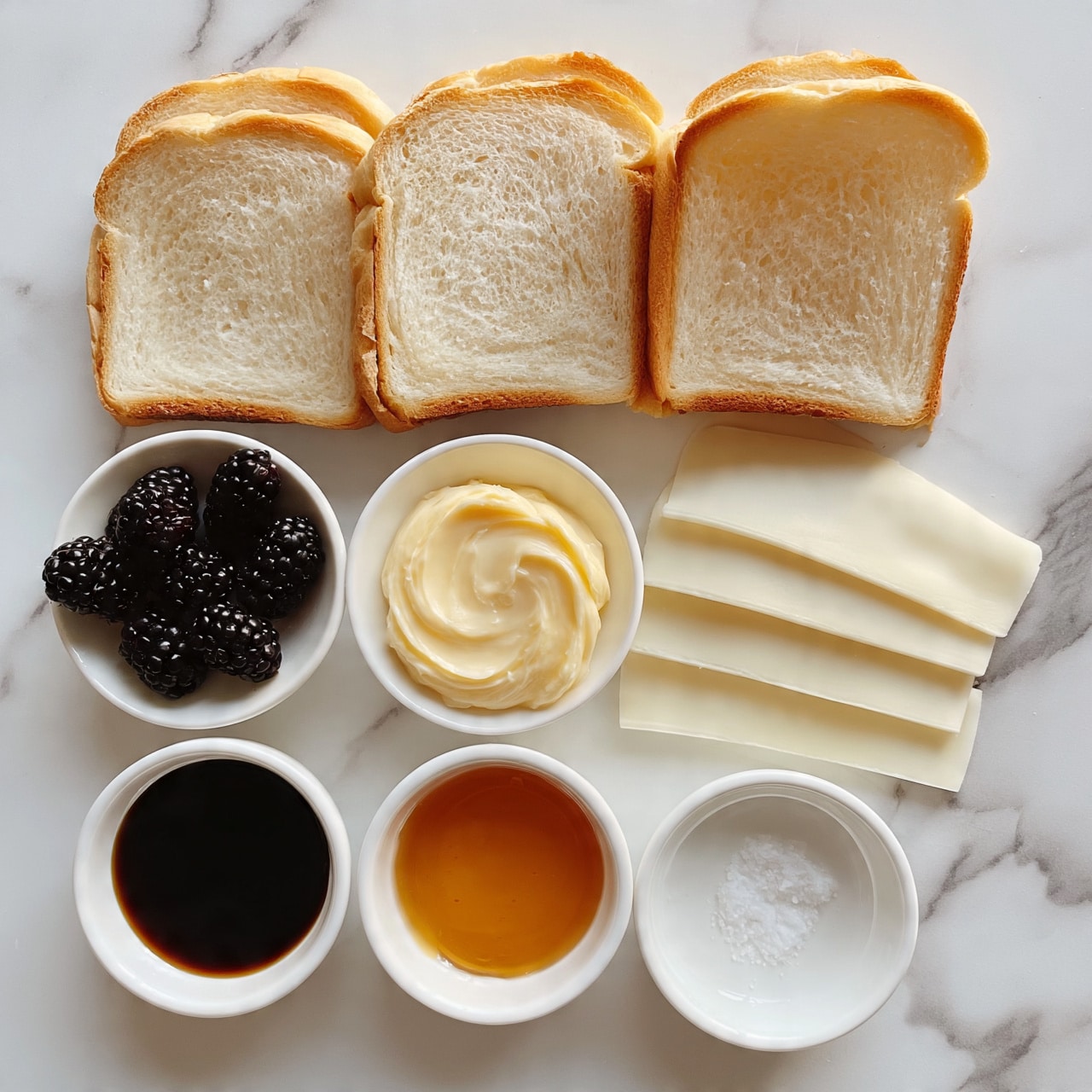 square image Three slices of light golden brown bread with soft, pale interiors are arranged in a row at the top. Below them are five thin, creamy white cheese slices placed overlapping on the right side. To the left of the cheese is a small white bowl filled with dark blackberries. Next to the blackberries is another small white bowl with a swirl of light yellow butter. Below these are three small white bowls: one with thick dark brown syrup, one with amber-colored honey, and the last with a few white grains of salt. All of these items rest on a clean white marbled surface. photo taken with an iphone --ar 4:5 --v 7