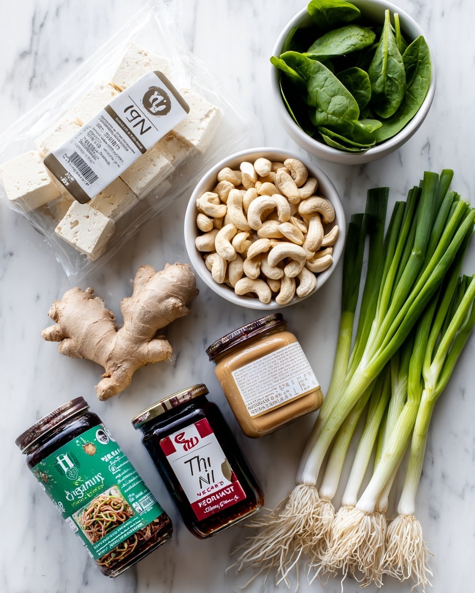 square image The image shows ingredients arranged on a white marbled surface, including a clear plastic package of organic tofu at the top left, a small white bowl filled with cashews below it, and a jar of creamy almond butter with a brown lid to the right of the tofu. Below the cashews is a green and white packet of Pad Thai rice noodles. Next to the almond butter is a jar of hoisin sauce with a red lid. Near the center are fresh ginger root and a whole garlic bulb. On the right side are several long green onions arranged neatly, with a white bowl filled with fresh green spinach leaves at the upper right corner. Photo taken with an iphone --ar 4:5 --v 7