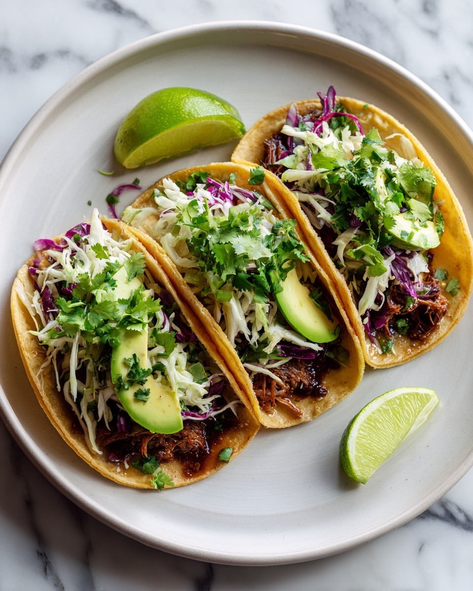 Three small tacos sit side by side on a round white plate, each taco filled with a base layer of dark brown cooked fish pieces. On top of the fish is a mix of white and purple shredded cabbage with thin green herbs scattered throughout. Bright green avocado slices and fresh green cilantro leaves are placed on each taco, adding a fresh look. A small lime wedge rests near the back of the plate. The plate sits on a white marbled surface, and the scene is bright and colorful. photo taken with an iphone --ar 4:5 --v 7