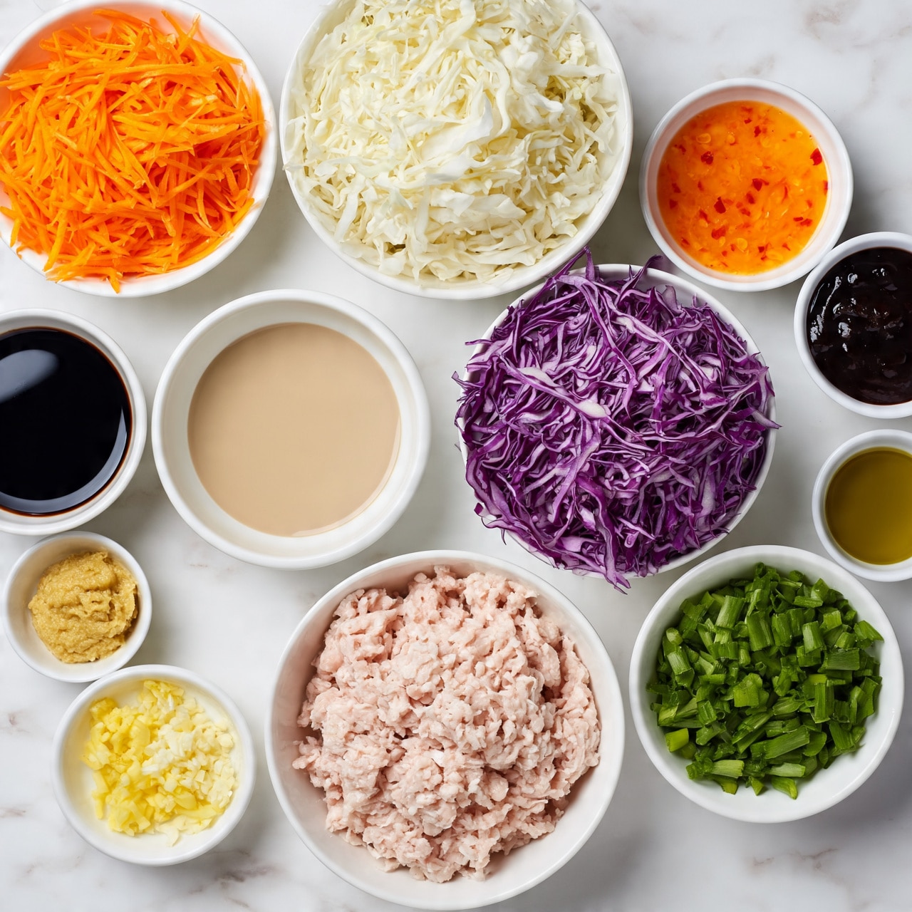 square image A top-down view of various white bowls filled with raw ingredients on a white marbled surface, showing a large bowl of light pink ground meat at the bottom center, to its right a bowl of chopped green onions, above that a bowl filled with thinly sliced purple cabbage, at the top center a bowl of shredded white cabbage, to the left of it a bowl of shredded bright orange carrots, and smaller white bowls scattered around them containing dark soy sauce, light mustard-colored paste, beige liquid, dark thick sauce, bright orange chili sauce with red bits, finely chopped yellow ginger, minced white garlic, and olive oil. Photo taken with an iphone --ar 4:5 --v 7