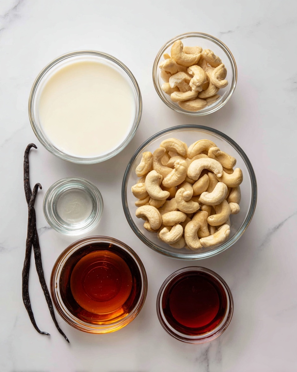 Five clear glass bowls are placed on a white marbled surface. The biggest bowl at the top left is filled with white coconut milk, smooth in texture. To the right of it is a medium bowl filled with whole cashew nuts, light beige and slightly curved. Below the cashews, a larger bowl holds dark amber maple syrup, shiny and thick. To the left of the syrup, a small bowl contains clear liquid, likely water or another syrup. Below that, another tiny bowl holds a reddish-brown liquid. To the far left, a single dark brown vanilla bean pod lies flat on the surface. photo taken with an iphone --ar 4:5 --v 7