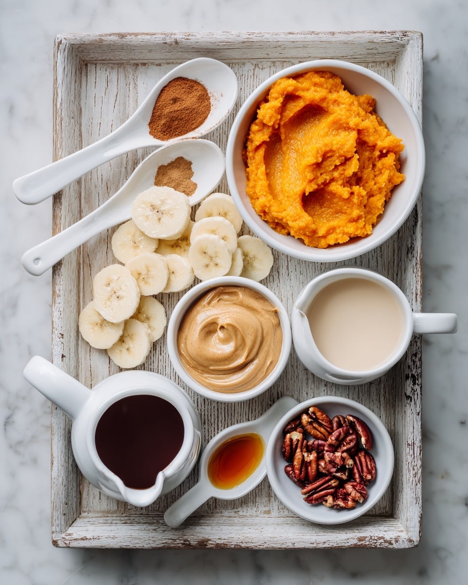 A white wooden tray with a worn look holds several small white bowls and spoons arranged neatly. On the top right, there is a white bowl filled with bright orange mashed sweet potatoes with a soft, smooth texture. To the left, two white spoons contain cinnamon powder, one spoonful more than the other. Below them, a small white bowl holds creamy light brown peanut butter with a gentle swirl on top. In the center, a white bowl is filled with banana slices that are pale yellow and smooth, standing out against the other colors. Just below, a white jug contains light beige creamy liquid, likely a milk substitute. To the bottom left, a white bowl holds a dark brown thick syrup. In the lower right corner, a white bowl contains reddish-brown pecan nuts with textured surfaces. Next to it, a white spoon holds a small amount of amber-colored syrup. The tray sits on a white marbled surface. Photo taken with an iphone --ar 4:5 --v 7