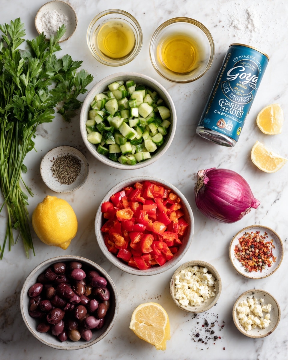 The image shows clear white bowls and a can placed on a white marbled surface with fresh ingredients inside and around them. In the center is a bowl filled with chopped red bell peppers, bright and textured. Above that is a bowl with green chopped cucumbers, cut into uneven chunky pieces. To the left is a bunch of fresh green parsley leaves. Below the pepper bowl is a bowl filled with shiny dark purple olives. To the right of the olives, a blue can labeled