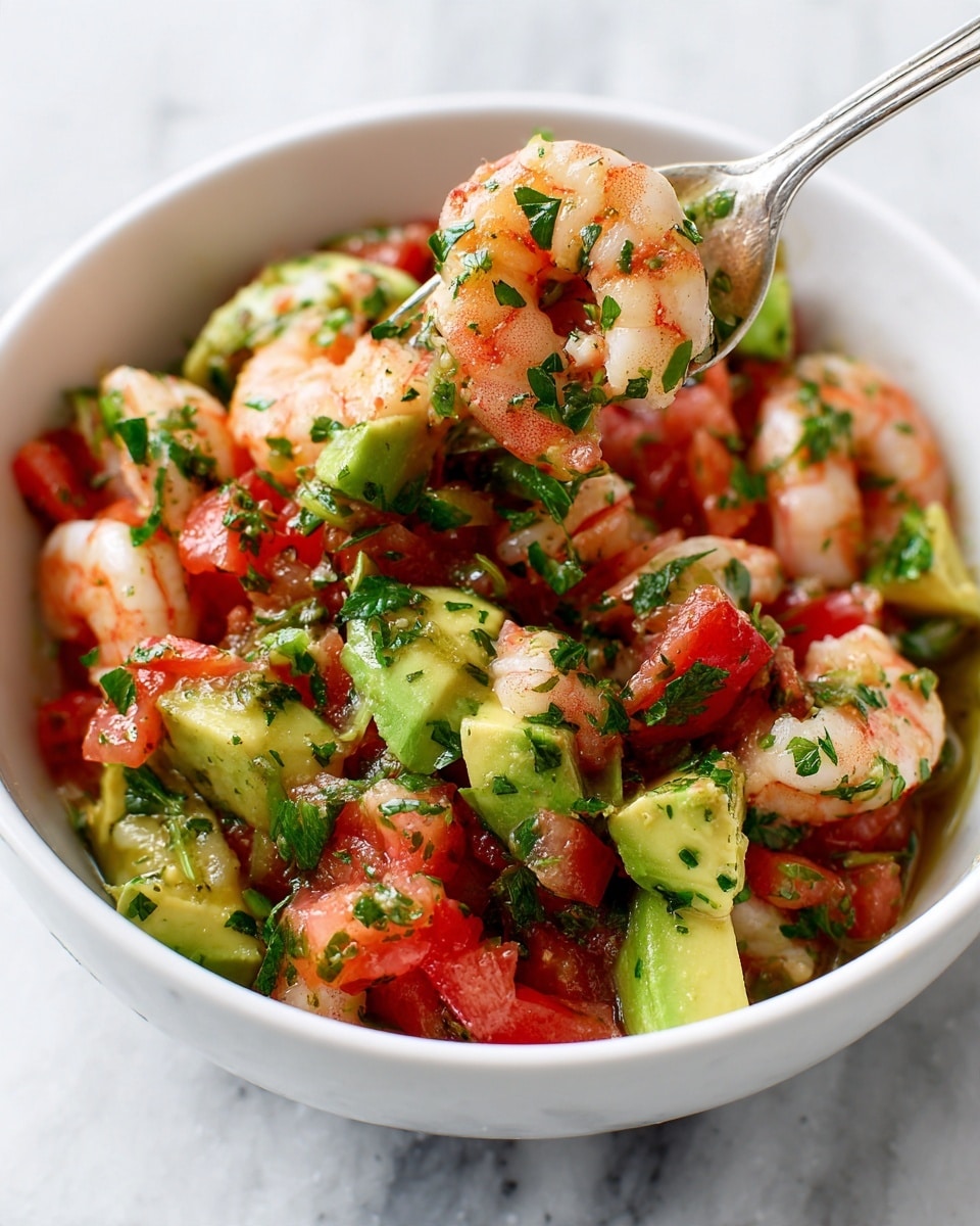 A white bowl filled with a colorful shrimp salad featuring three main layers: the first layer contains plump, pink shrimp scattered throughout; the second layer has bright red tomato chunks mixed evenly; and the third layer shows creamy, green avocado pieces on top, all tossed together with fresh green parsley leaves and a light dressing that adds a glossy texture. A silver fork holds a bite-sized mix of shrimp, tomato, and avocado, positioned above the bowl. The whole dish sits on a white marbled surface. Photo taken with an iphone --ar 4:5 --v 7