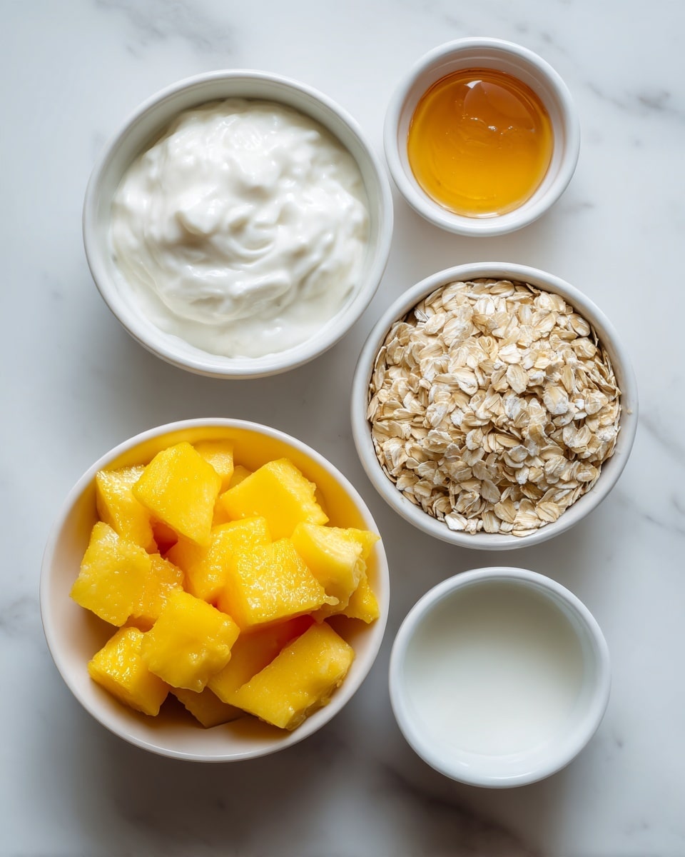The image shows five white bowls arranged on a white marbled surface. The largest bowl centered near the bottom contains bright yellow frozen mango chunks with a frosty texture. Above it, slightly to the left, is a medium bowl filled with thick, creamy white yogurt. To the left is a smaller bowl with light beige rolled oats that have a dry, rough texture. On the right side at the top is a small bowl holding golden amber honey that looks smooth and shiny. Finally, near the center right is an empty small white bowl. The overall view is bright with soft natural light. photo taken with an iphone --ar 4:5 --v 7