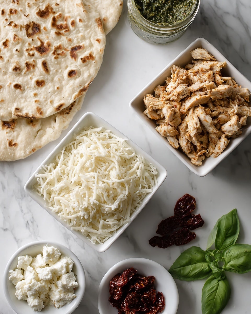 Two small white square bowls sit on a white marbled surface, one filled with shredded white cheese and the other with shredded light brown chicken pieces. Below them, separate small piles include dark red sun-dried tomatoes, a small jar of green pesto, and a small white bowl containing crumbly white cheese. On the left side of the image, there is a piece of flatbread with light brown toasted spots. A few fresh green basil leaves are placed near the bottom right corner. Photo taken with an iphone --ar 4:5 --v 7