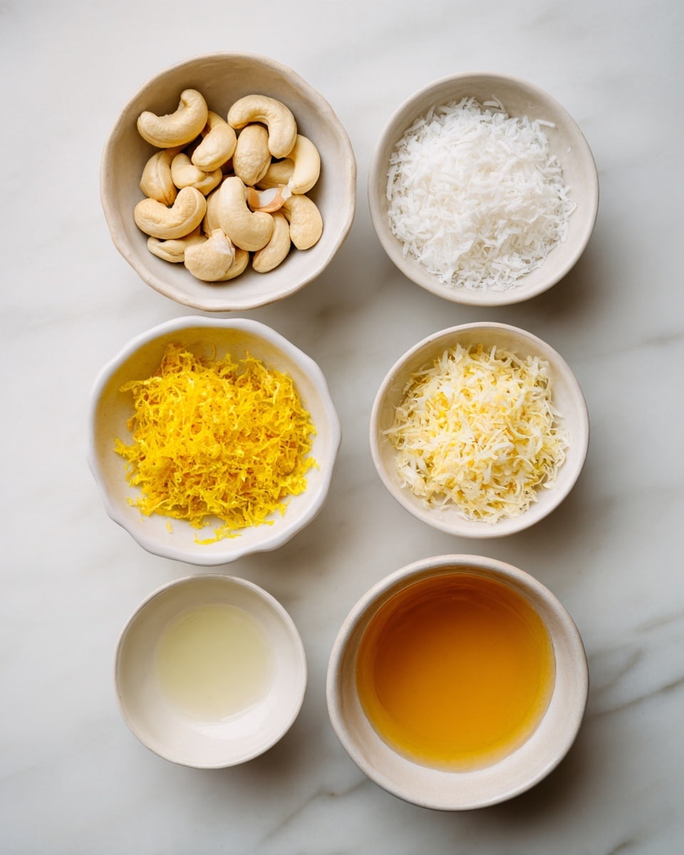 The image shows five small white bowls on a white marbled surface, each containing a different ingredient. At the top left, a bowl holds whole cashew nuts in an off-white color with smooth texture. Next to it on the right, a bowl is filled with fine white shredded coconut. On the bottom left, a bowl contains bright yellow lemon zest with a soft, fine texture. In the middle bottom, a bowl has clear liquid with a slightly glossy surface. On the bottom right, a bowl holds a golden honey-like liquid with a smooth texture. The bowls are evenly spaced and neatly arranged. photo taken with an iphone --ar 4:5 --v 7