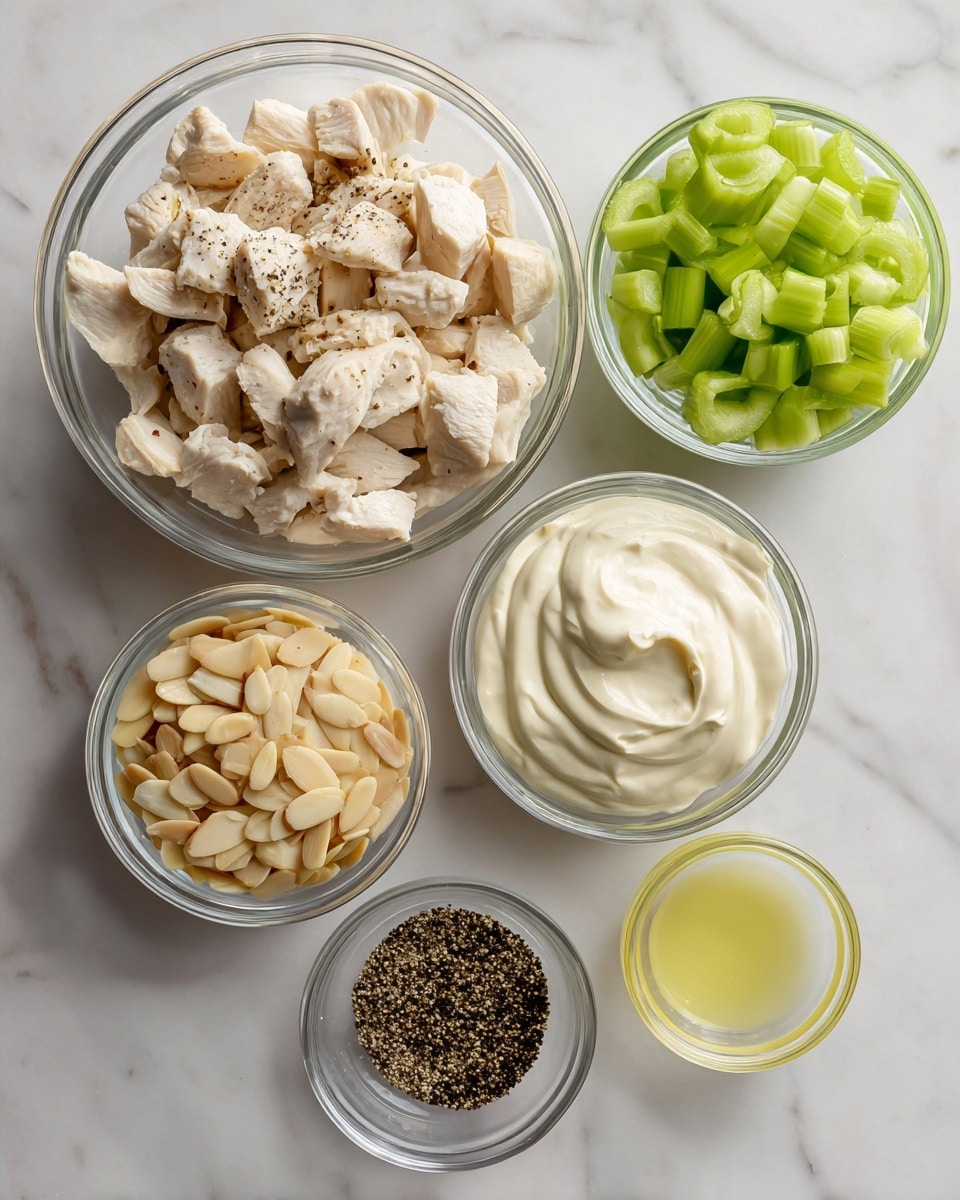 The image shows six clear glass bowls placed on a white marbled surface. The largest bowl on the left is filled with chopped cooked chicken pieces, white with light brown edges and some black pepper seasoning scattered on top. Above it is a smaller bowl with bright green celery pieces cut into small round slices. To the right of the celery bowl is another medium bowl with creamy white mayonnaise that has a smooth and thick texture. Below the mayo is a small bowl with coarsely ground black pepper, showing a mix of black and dark brown grains. To the left of the pepper, there is another small bowl filled with pale slivered almonds, long and thin in shape. In the center, below the celery bowl, a small bowl contains light yellow lemon juice with a slightly oily surface. All bowls are evenly spaced and arranged in a loose circular pattern. photo taken with an iphone --ar 4:5 --v 7