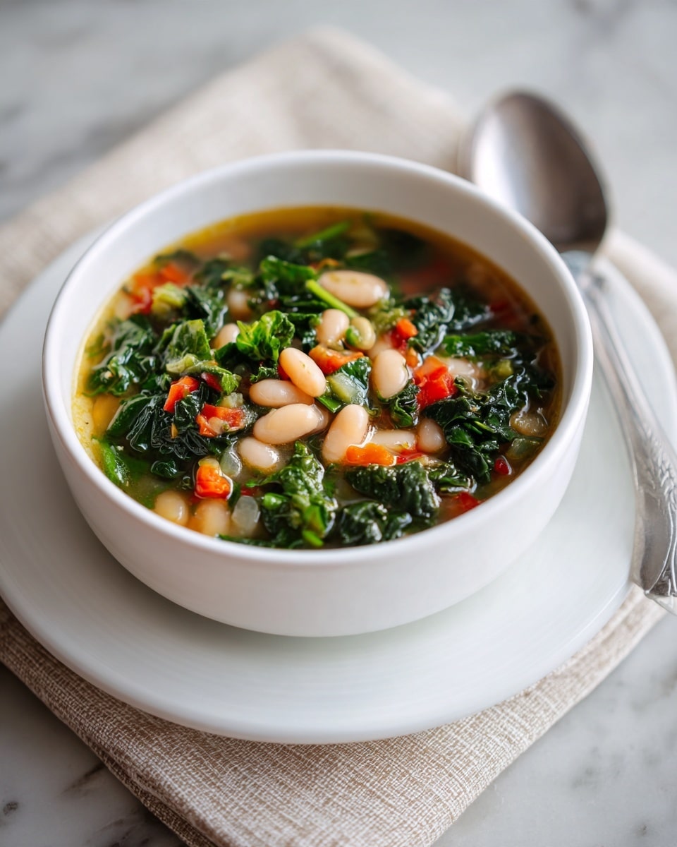 A white bowl filled with a colorful soup is sitting on a white marbled surface. The soup has layers of small white beans, green leafy vegetables, and small pieces of red and orange vegetables floating on top in a clear broth. The white bowl sits on a matching white plate with a textured beige napkin and silver spoon nearby. The lighting is soft and natural, making the soup look fresh and warm. Photo taken with an iphone --ar 4:5 --v 7