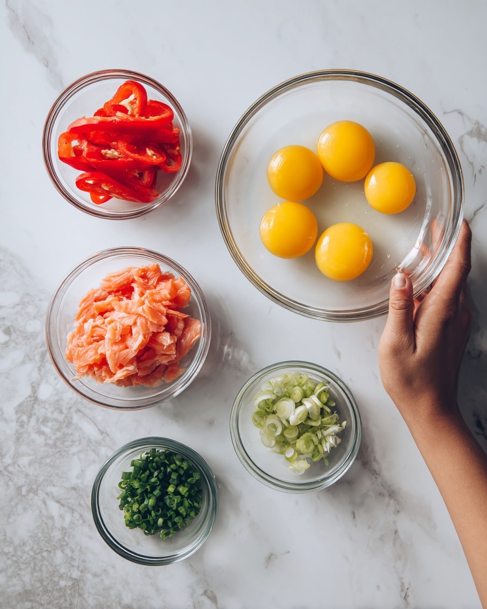 The image shows four clear glass bowls on a white marbled surface. One large bowl contains four raw eggs with bright yellow yolks floating in clear egg whites. Next to it, a smaller bowl holds two whole red bell peppers. Another small bowl contains thin pink slices of smoked salmon. The last small bowl has finely chopped green onions, adding a fresh green color. A woman's hand is holding one of the bowls. Photo taken with an iphone --ar 4:5 --v 7